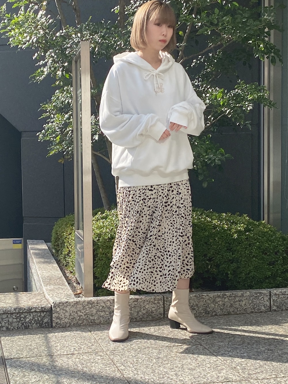 ホワイト系のパーカー、ホワイト系のスカートを着用したレディースの冬コーディネートの3枚目の写真