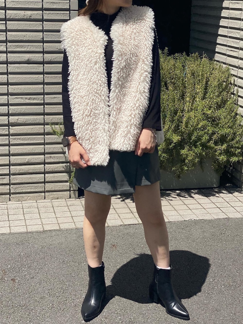 ホワイト系のベスト、ホワイト系のハットを着用したレディースの夏コーディネートの2枚目の写真