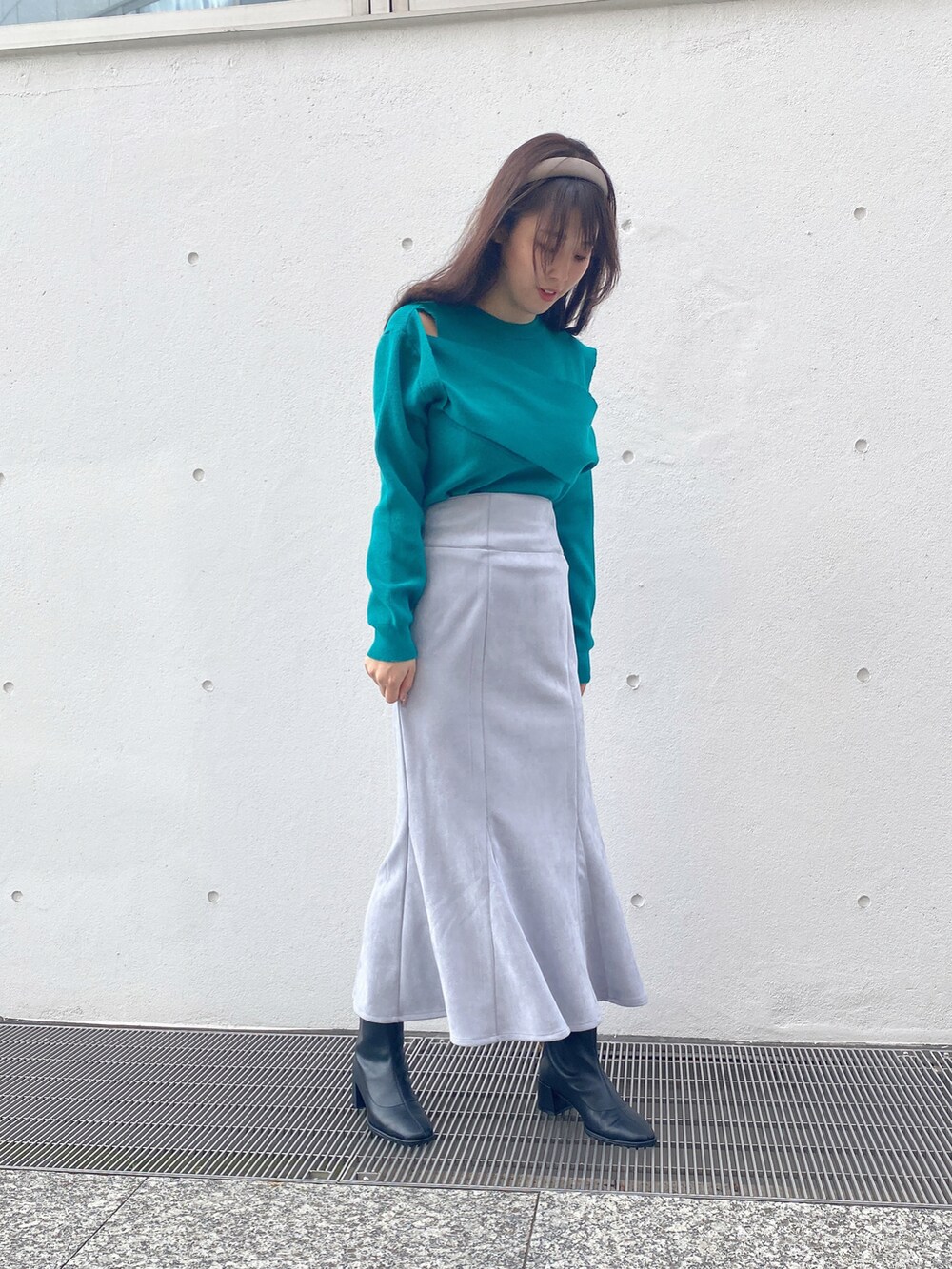 グリーン系のニット/セーター、ブルー系のスカートを着用したレディースの冬コーディネートの3枚目の写真