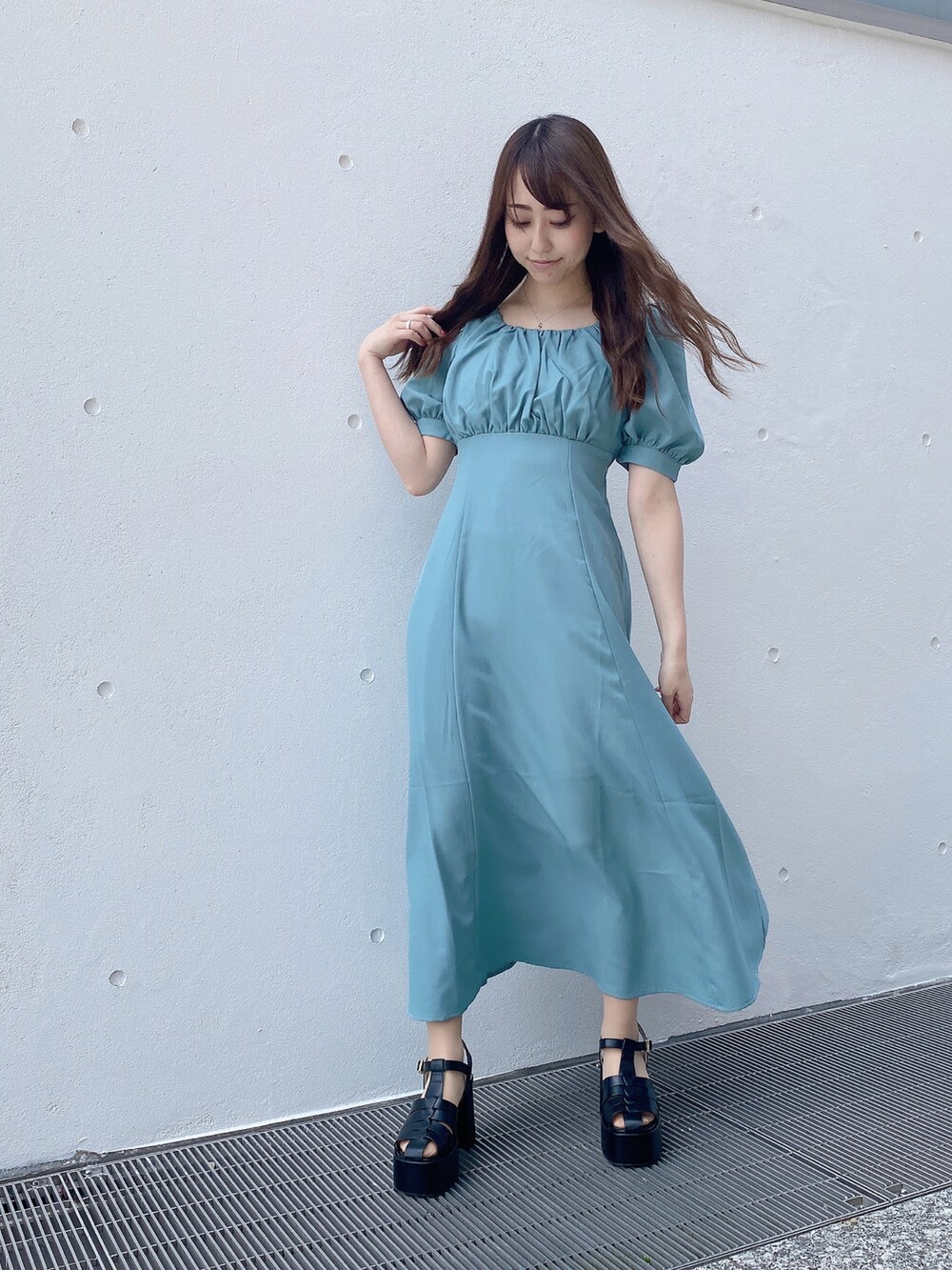 グリーン系のワンピース、ブラック系のサンダルを着用したレディースの夏コーディネートの3枚目の写真