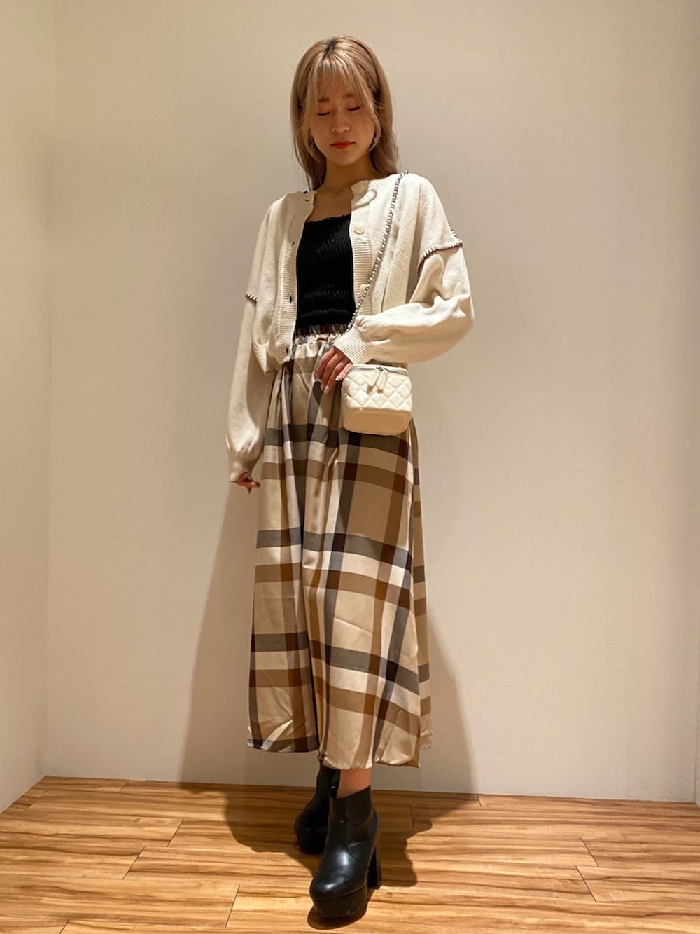 ホワイト系のカーディガン/ボレロ、ベージュ系のスカートを着用したレディースの秋コーディネートの2枚目の写真