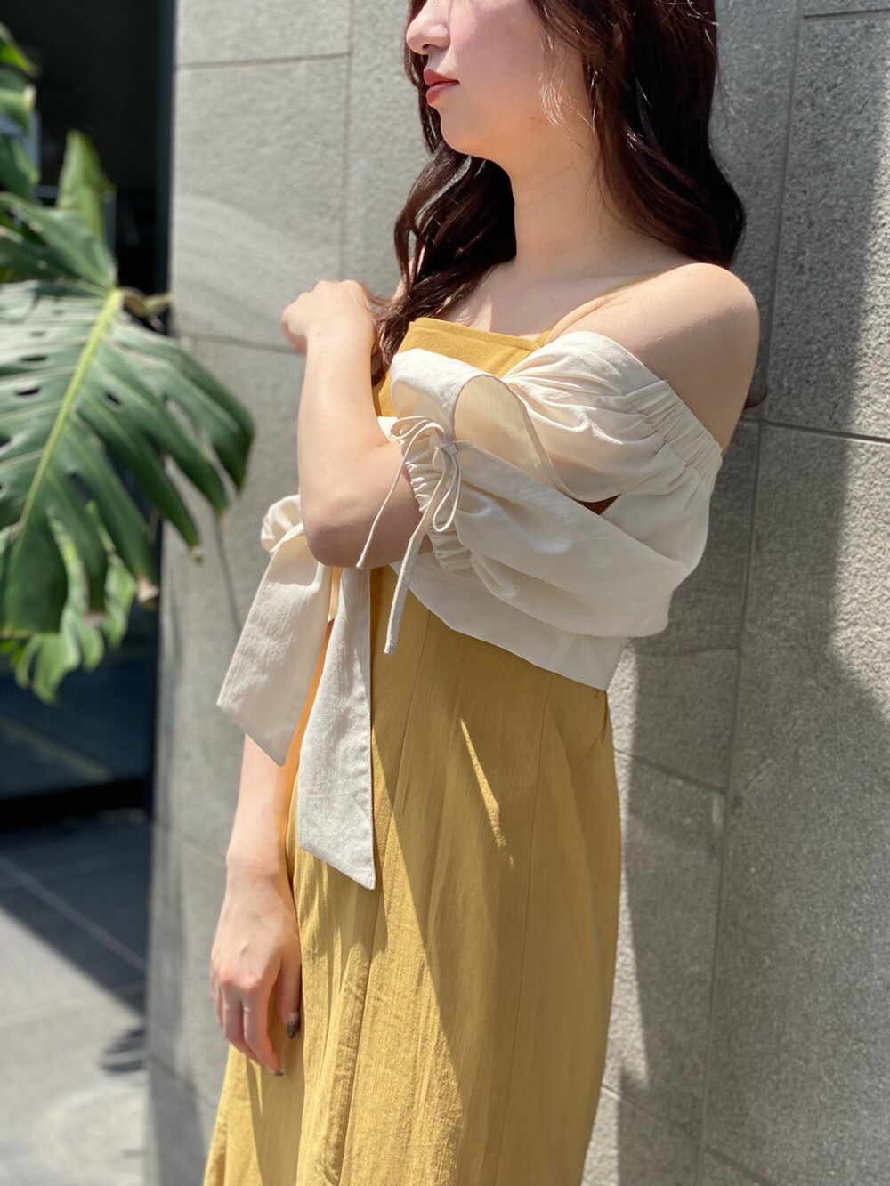 イエロー系のワンピースを着用したレディースの夏コーディネートの4枚目の写真