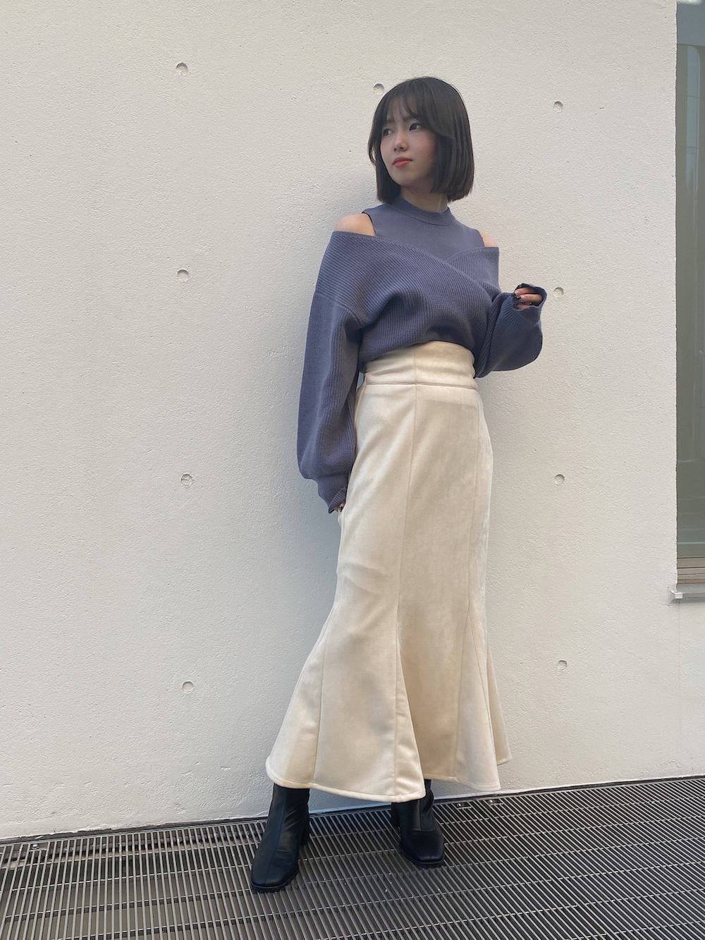 ホワイト系のスカート、グレー系のニット/セーターを着用したレディースの冬コーディネートの2枚目の写真