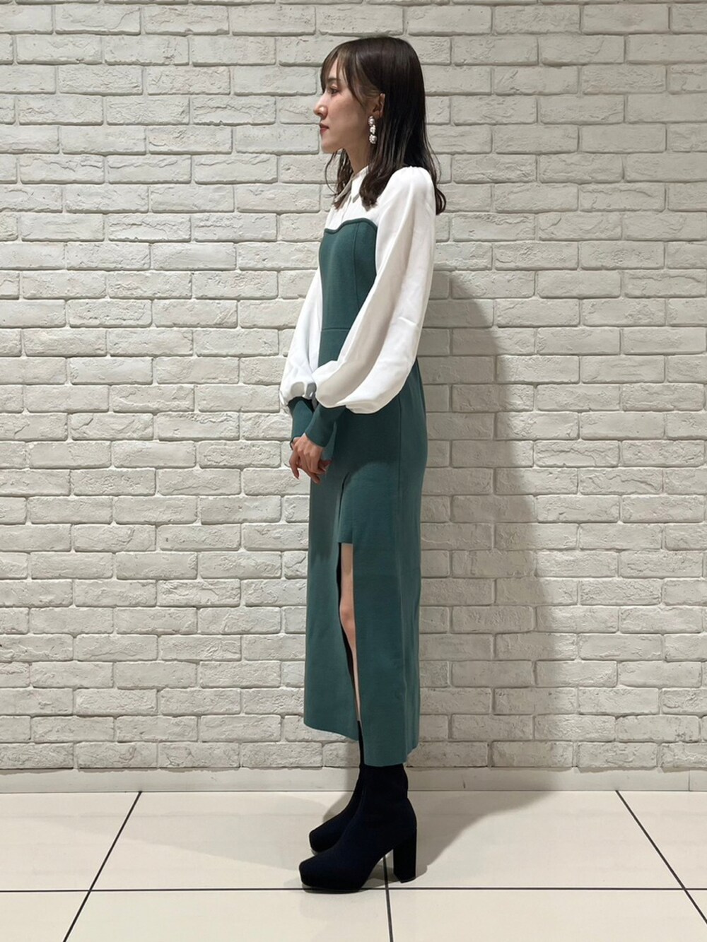 グリーン系のワンピースを着用したレディースの冬コーディネートの2枚目の写真