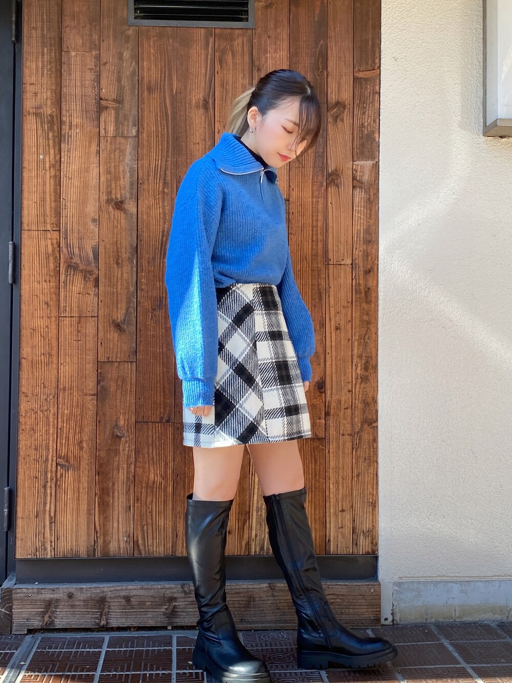 ブルー系のニット/セーター、ブラック系のニット/セーター、ホワイト系のスカートを着用したレディースの冬コーディネートの2枚目の写真