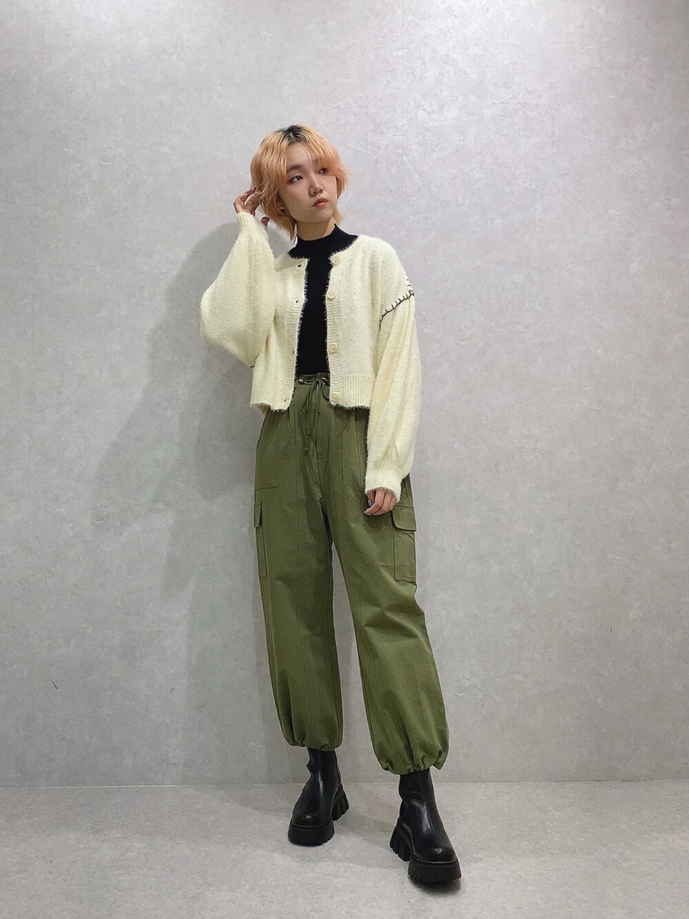 グリーン系のカーゴパンツ、ホワイト系のカーディガン/ボレロを着用したレディースの冬コーディネートの3枚目の写真