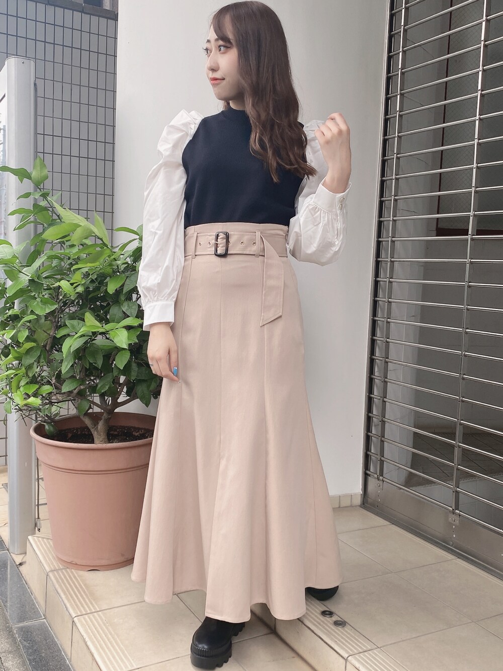 ベージュ系のスカートを着用したレディースの秋コーディネートの2枚目の写真