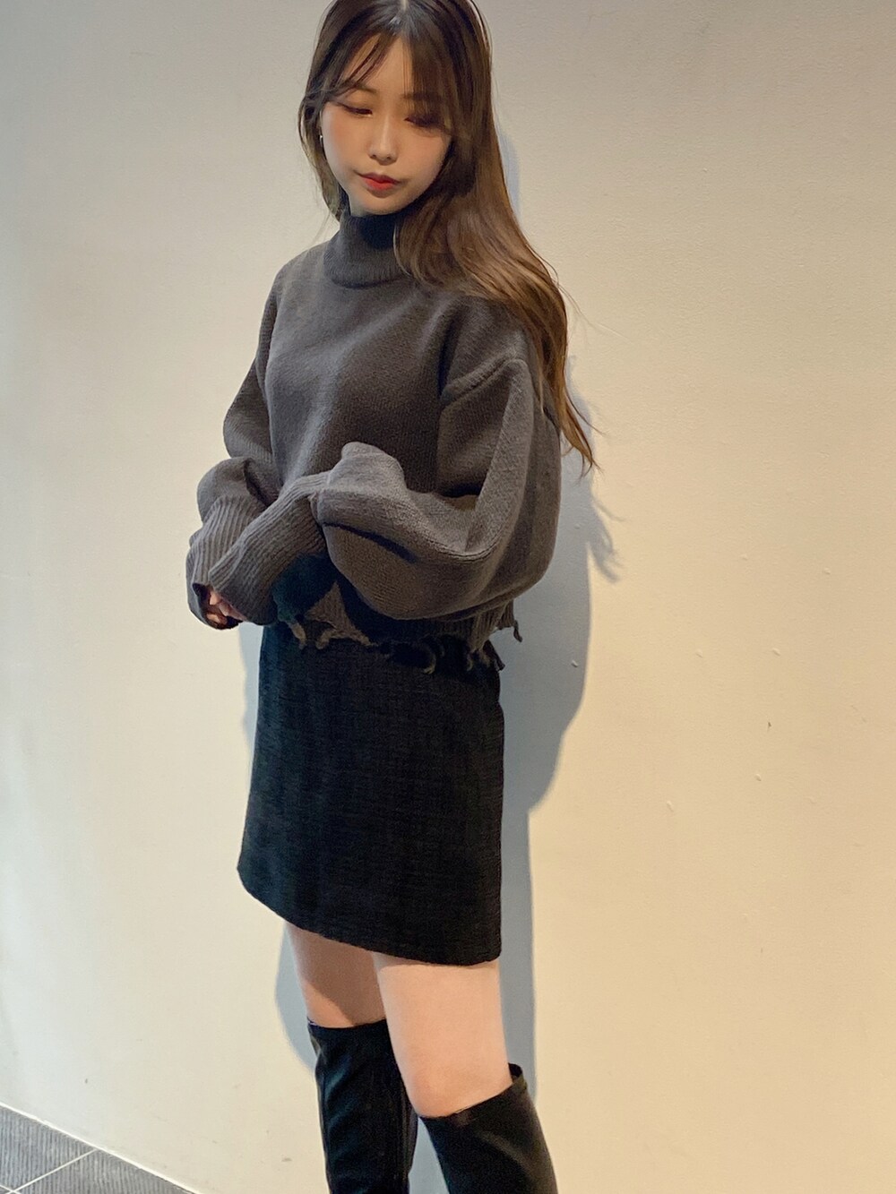 グレー系のニット/セーター、ブラック系のスカートを着用したレディースの冬コーディネートの3枚目の写真