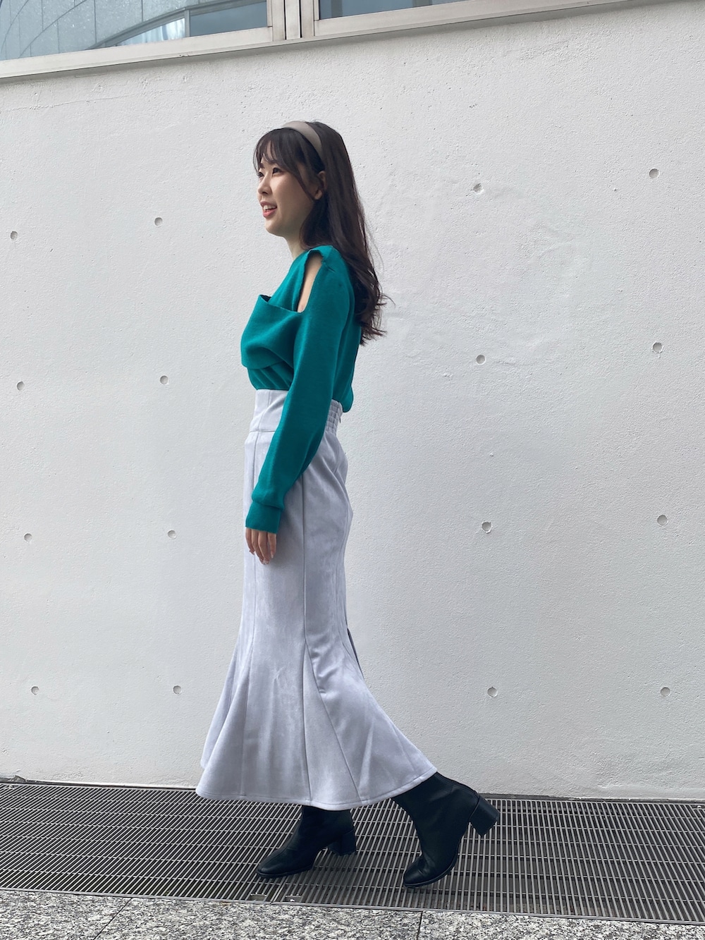 グリーン系のニット/セーター、ブルー系のスカートを着用したレディースの冬コーディネートの4枚目の写真