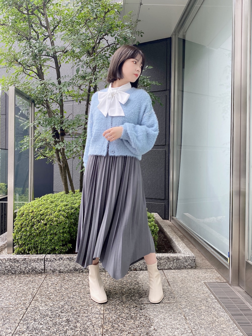 ホワイト系のシャツ/ブラウス、グレー系のスカート、ブルー系のカーディガン/ボレロを着用したレディースの秋コーディネートの3枚目の写真