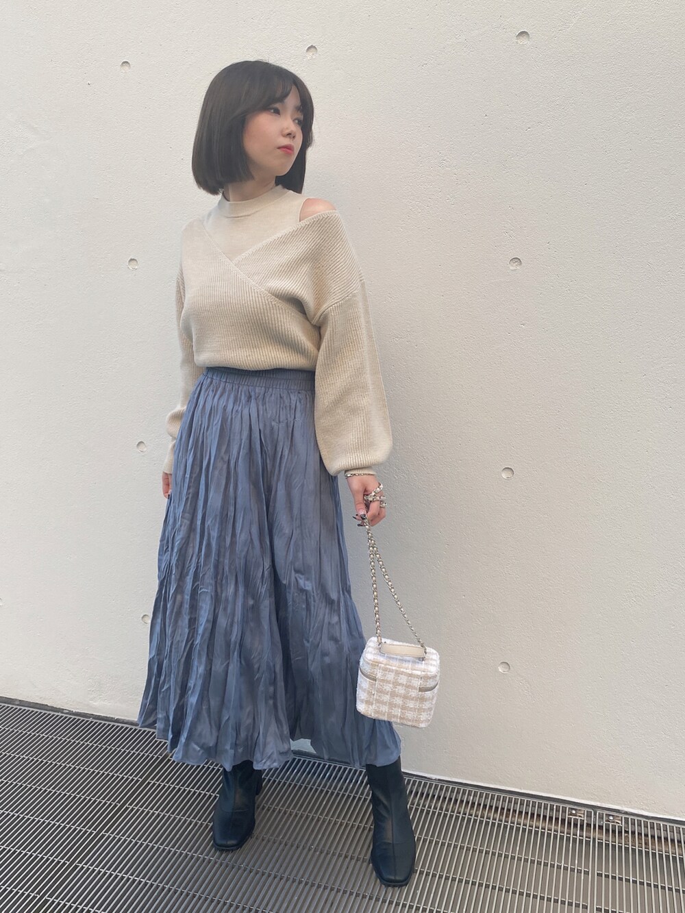 ベージュ系のニット/セーター、ブルー系のスカートを着用したレディースの冬コーディネートの3枚目の写真