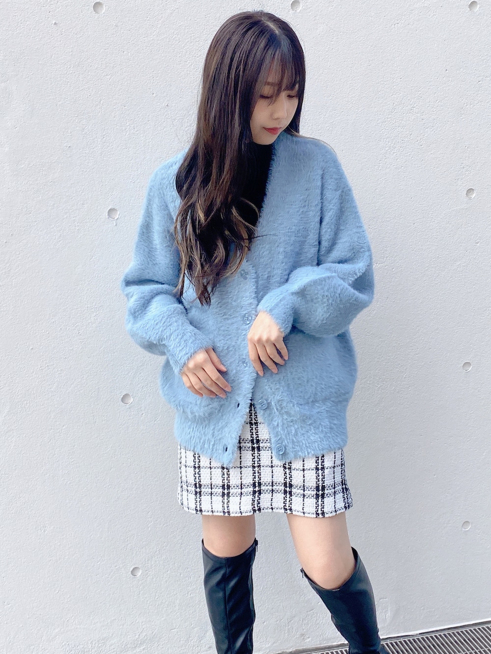 ホワイト系のスカート、ブルー系のカーディガン/ボレロを着用したレディースの冬コーディネートの2枚目の写真