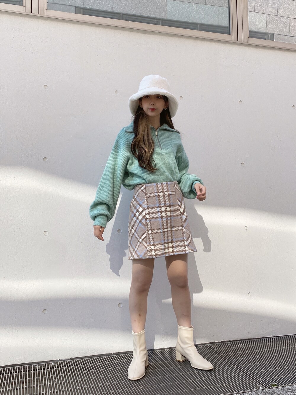 グリーン系のニット/セーター、ベージュ系のスカートを着用したレディースの冬コーディネートの3枚目の写真