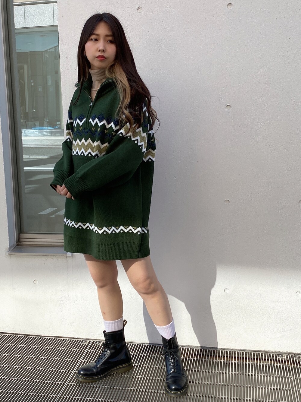 グリーン系のワンピース、ベージュ系のニット/セーターを着用したレディースの冬コーディネートの3枚目の写真