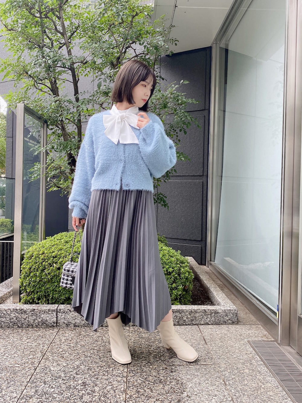 ホワイト系のシャツ/ブラウス、グレー系のスカート、ブルー系のカーディガン/ボレロを着用したレディースの秋コーディネートの4枚目の写真