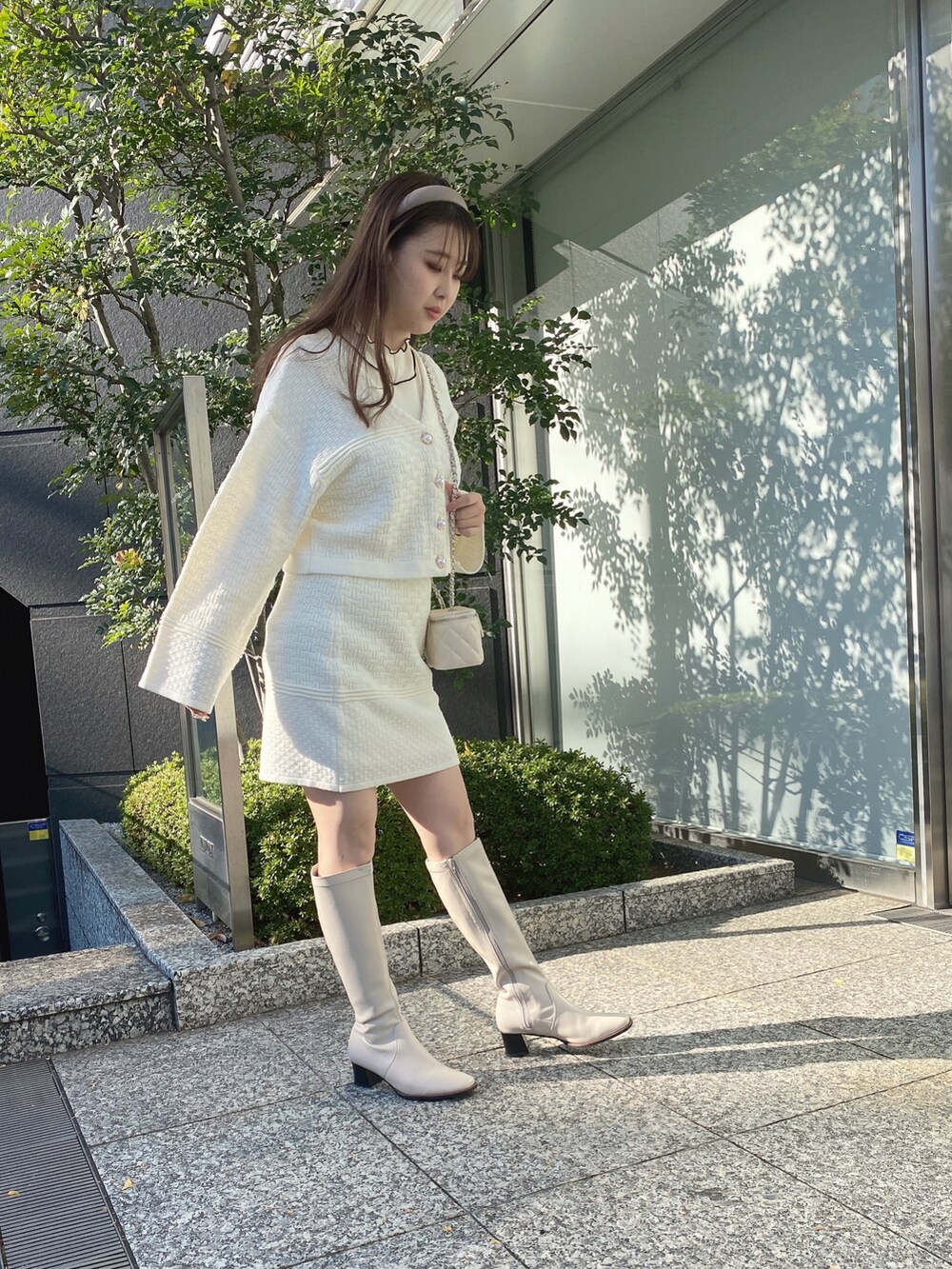 ホワイト系のカーディガン/ボレロ、ホワイト系のスカートを着用したレディースの冬コーディネートの4枚目の写真