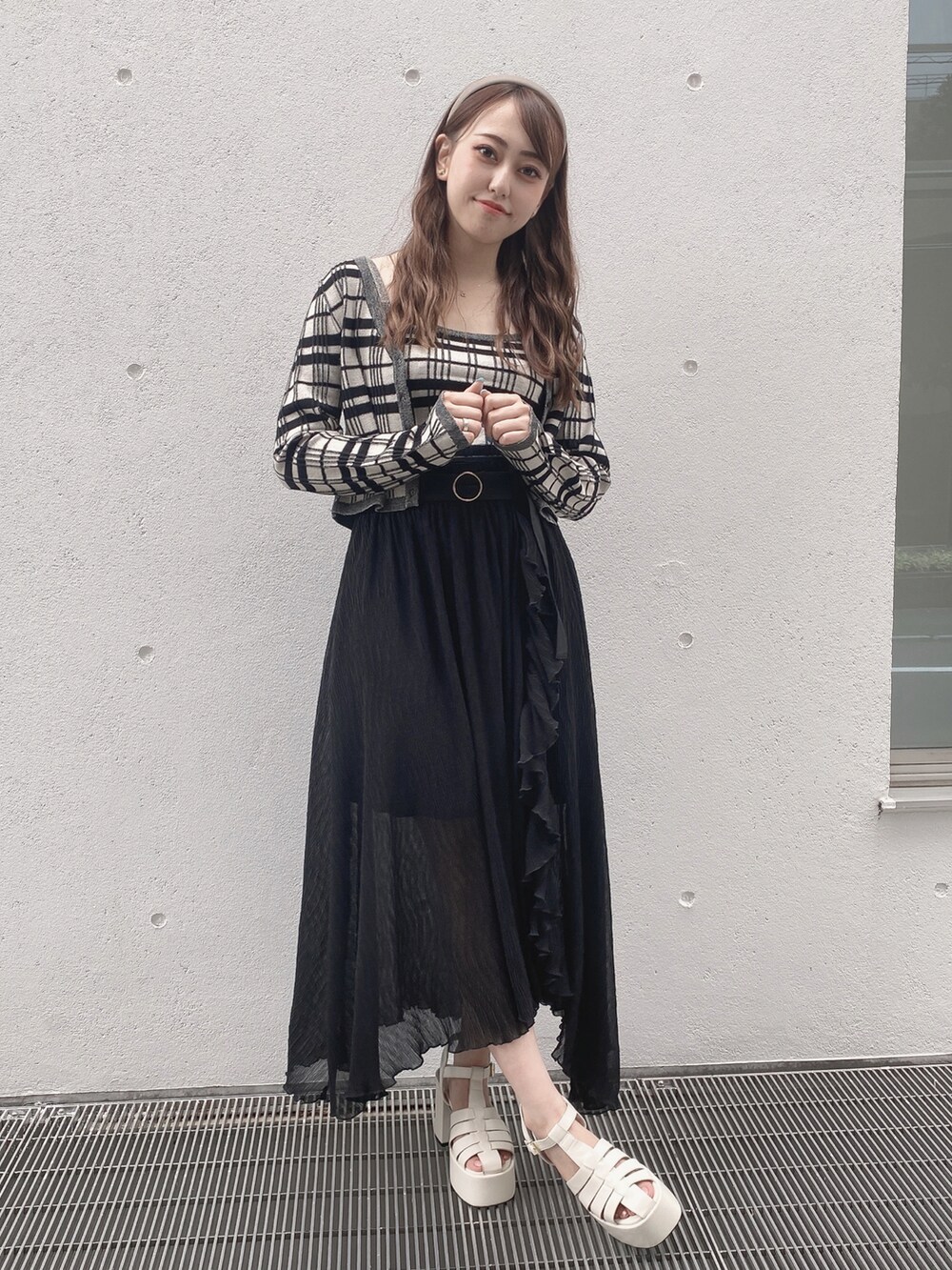 ブラック系のスカート、ホワイト系のサンダルを着用したレディースの夏コーディネートの2枚目の写真