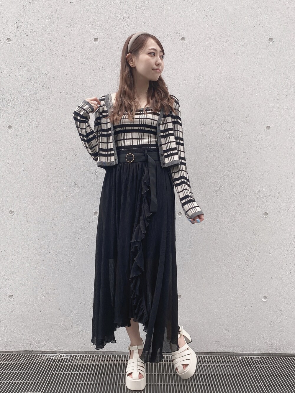 ブラック系のスカート、ホワイト系のサンダルを着用したレディースの夏コーディネートの3枚目の写真