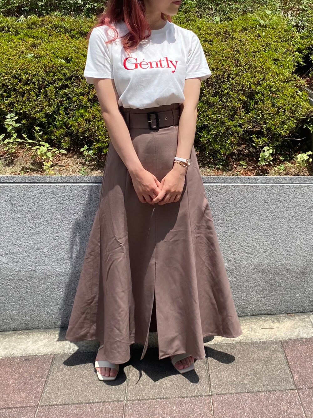 ブラウン系のスカート、ホワイト系のTシャツ/カットソーを着用したレディースの夏コーディネートの2枚目の写真