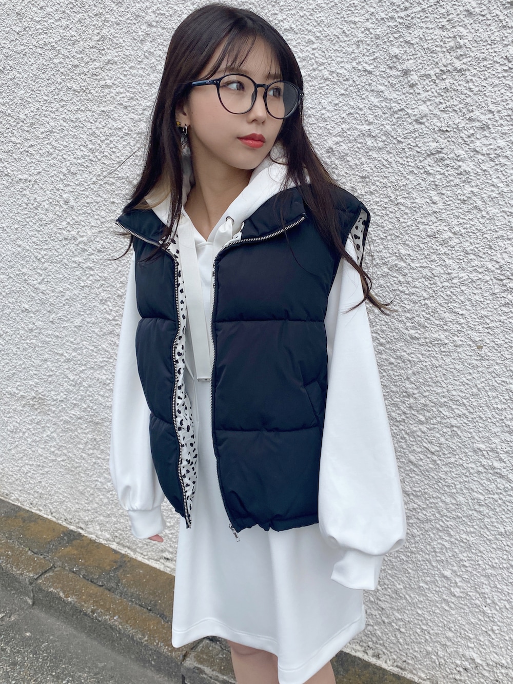 ホワイト系のワンピース、ブラック系のダウンベストを着用したレディースの秋コーディネートの3枚目の写真