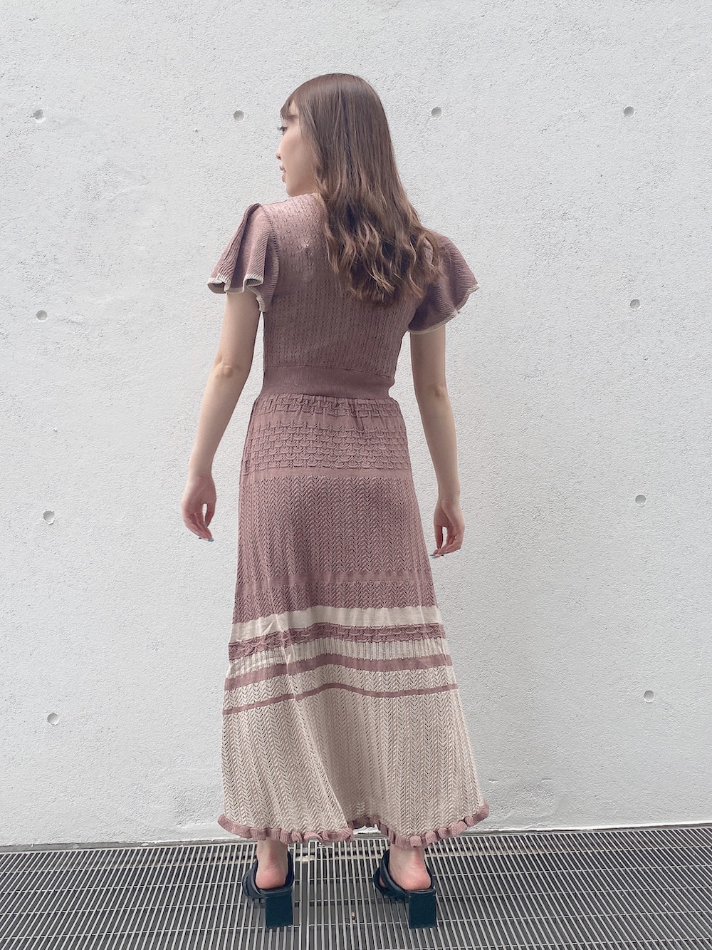 ピンク系のワンピースを着用したレディースの秋コーディネートの4枚目の写真