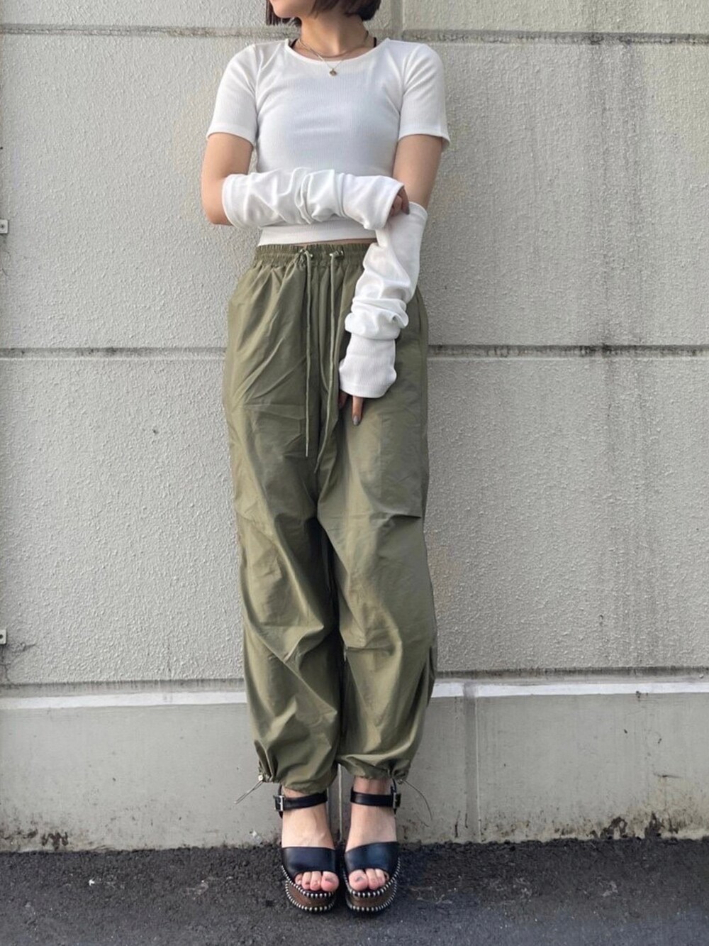 ホワイト系のTシャツ/カットソー、グリーン系のカーゴパンツ、ブラック系のサンダルを着用したレディースの夏コーディネートの2枚目の写真