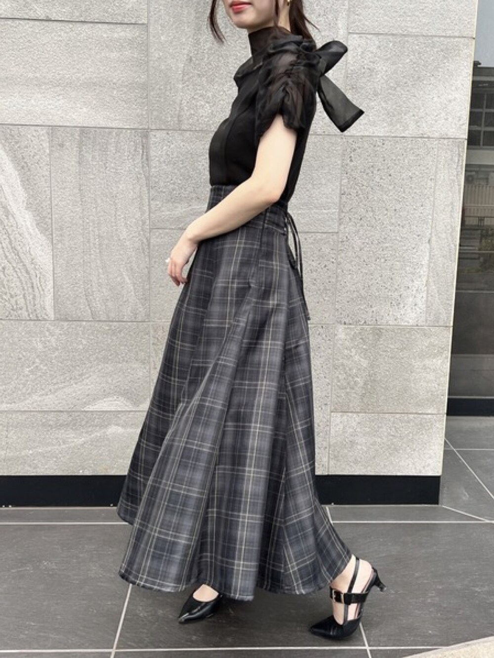 ブラック系のシャツ/ブラウス、グレー系のスカートを着用したレディースの夏コーディネートの2枚目の写真