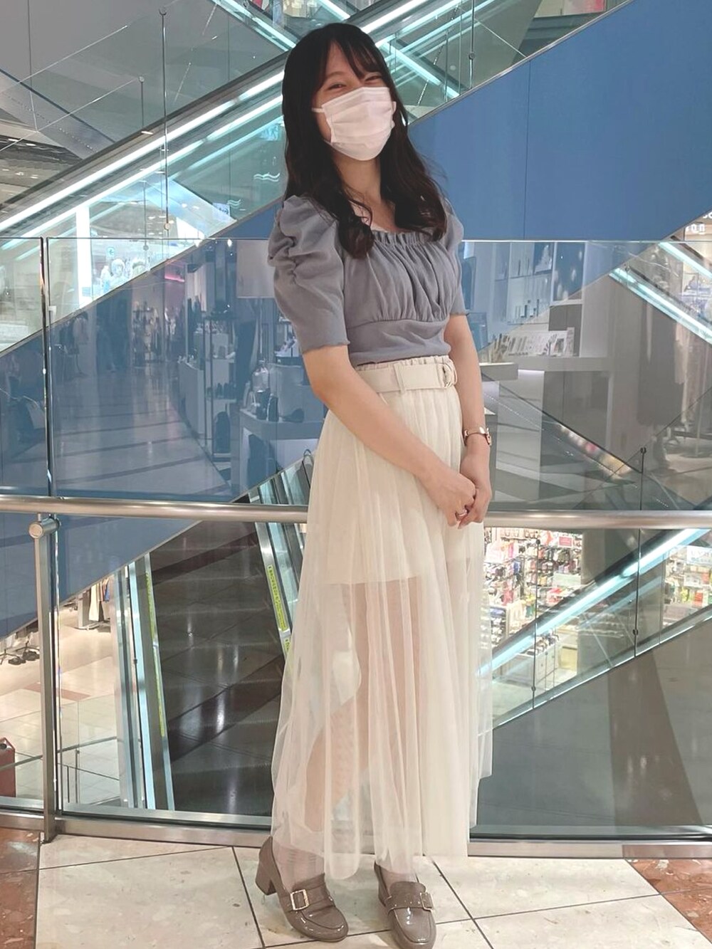 ベージュ系のスカートを着用したレディースの夏コーディネートの2枚目の写真