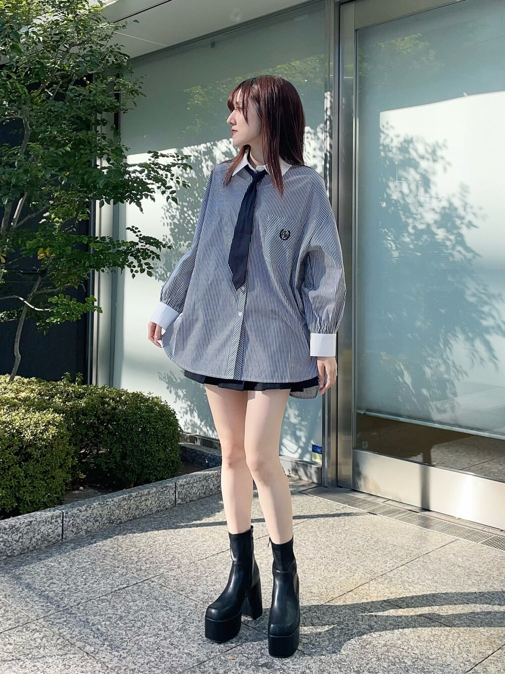 ホワイト系のカーディガン/ボレロ、ブラック系のシャツ/ブラウス、ブラック系のスカートを着用したレディースの春コーディネートの2枚目の写真