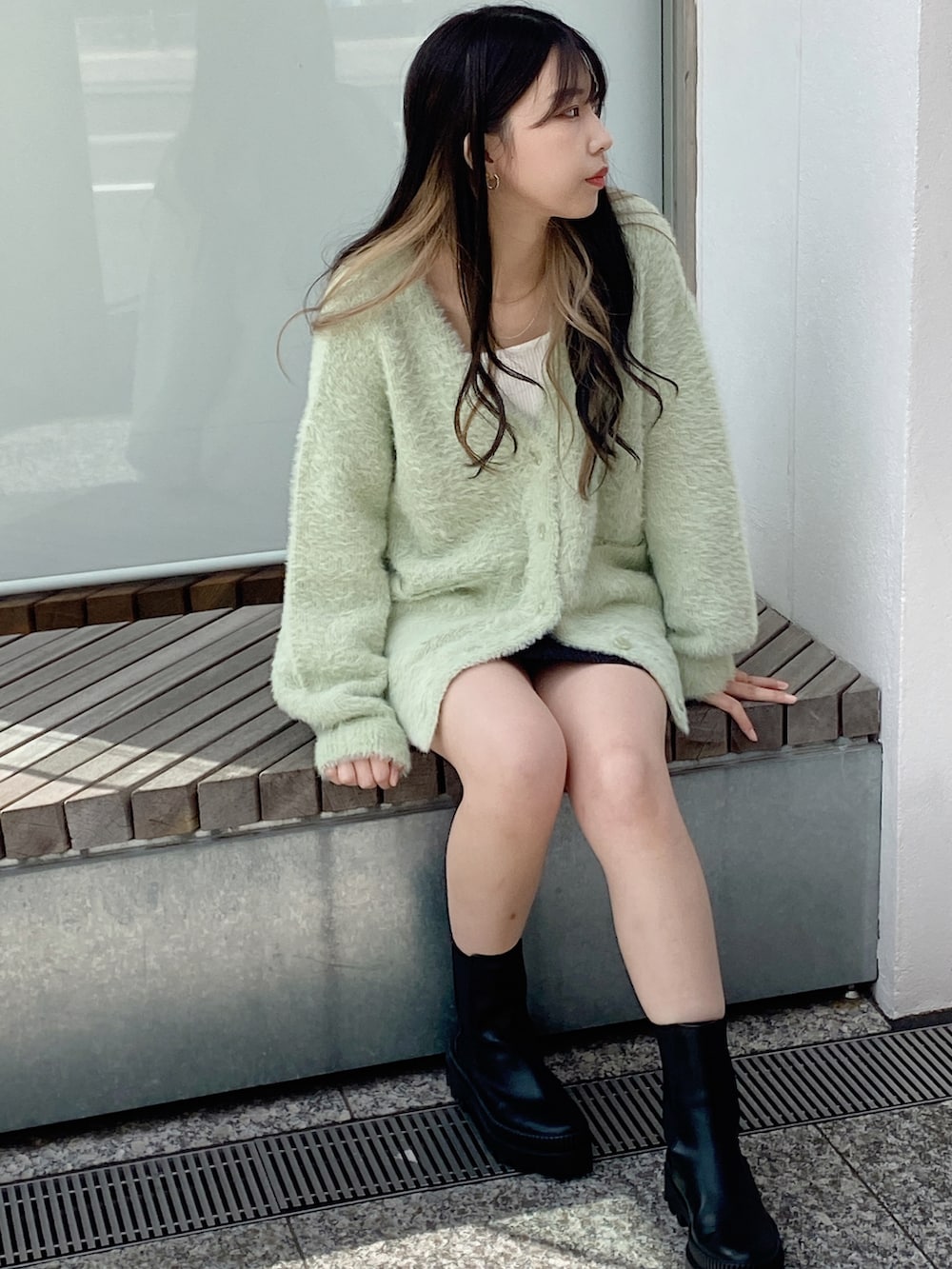 グリーン系のカーディガン/ボレロを着用したレディースの冬コーディネートの2枚目の写真