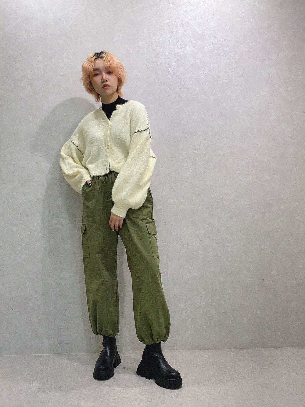 グリーン系のカーゴパンツ、ホワイト系のカーディガン/ボレロを着用したレディースの冬コーディネートの2枚目の写真