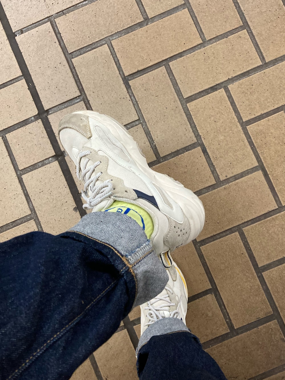 ホワイト系のスウェット、ホワイト系のスニーカー、ブルー系のデニムパンツを着用したレディースの秋コーディネートの2枚目の写真