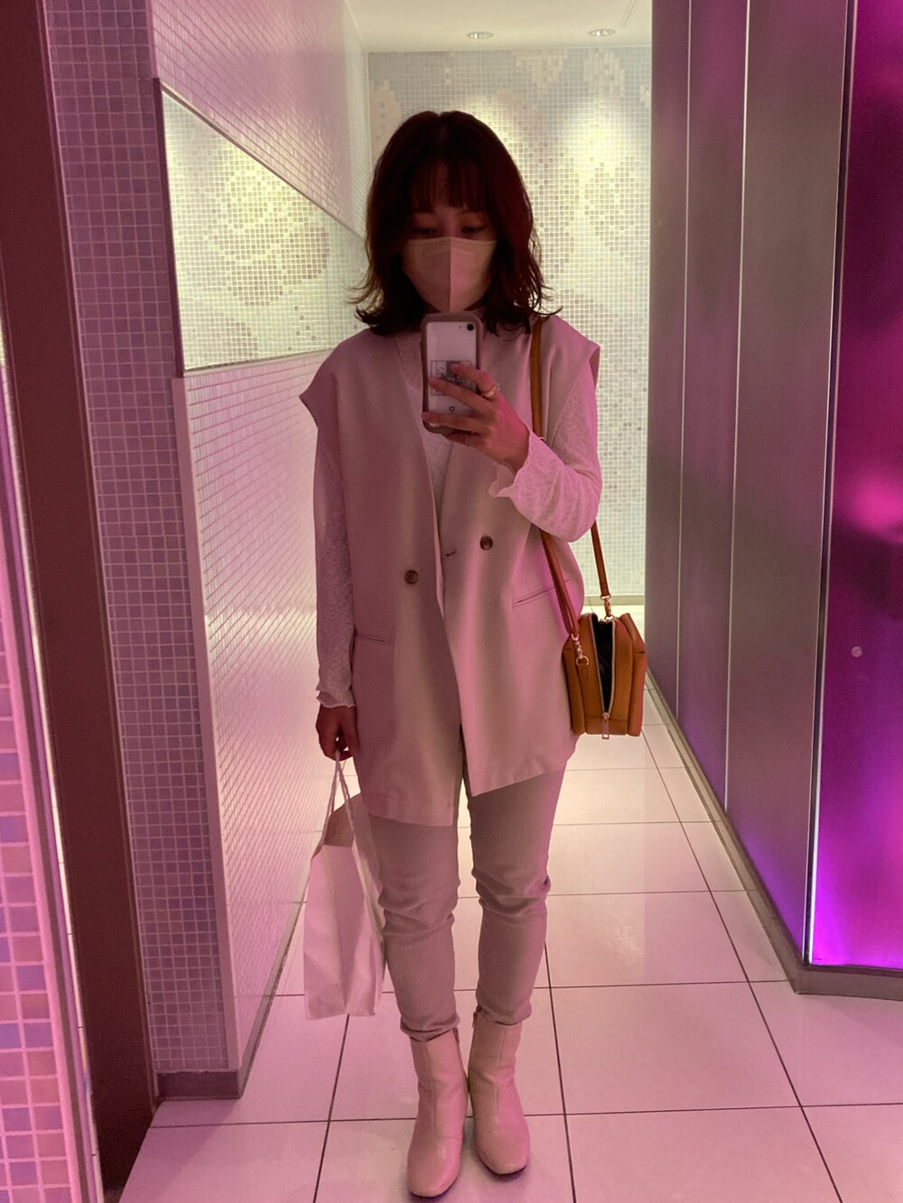 ベージュ系のベスト、ホワイト系のシャツ/ブラウス、ホワイト系のデニムパンツを着用したレディースの秋コーディネートの2枚目の写真