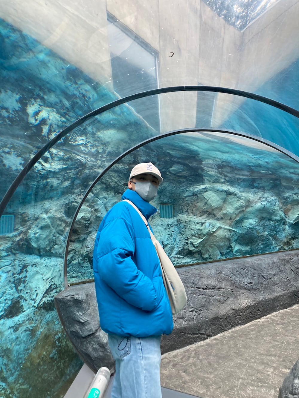 ブラック系のダウンジャケット/コート、ホワイト系のショルダーバッグ、ブルー系のデニムパンツを着用したメンズの冬コーディネートの2枚目の写真