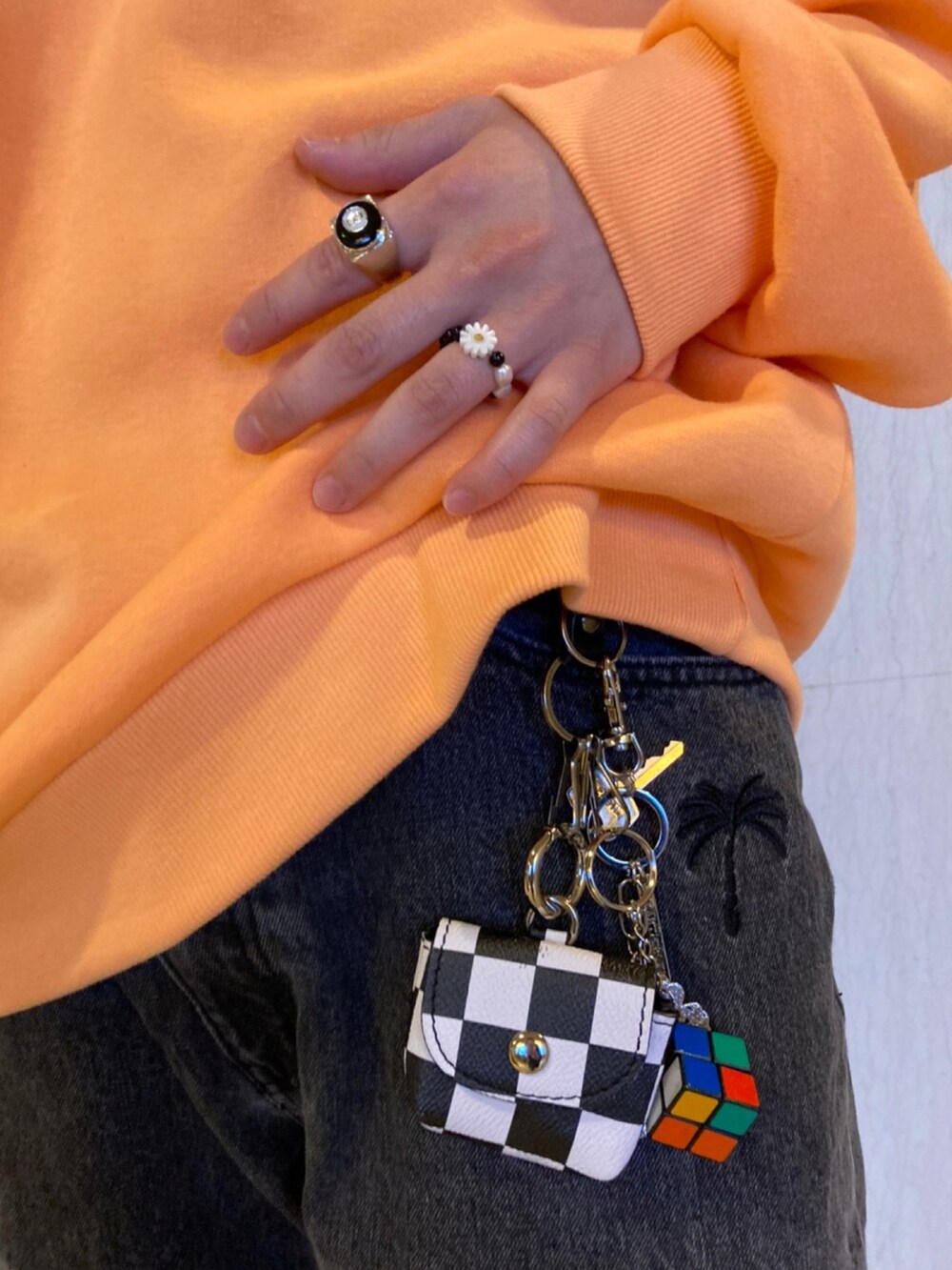 オレンジ系のスウェット、ブラック系のデニムパンツ、グレー系のスニーカーを着用したメンズの冬コーディネートの3枚目の写真