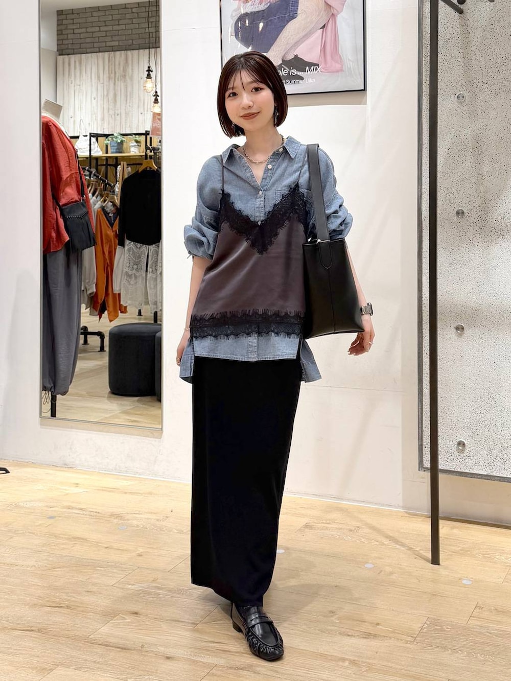 ブラック系のスカート、ブルー系のシャツ/ブラウス、ブラック系のトートバッグを着用したレディースの春コーディネートの6枚目の写真