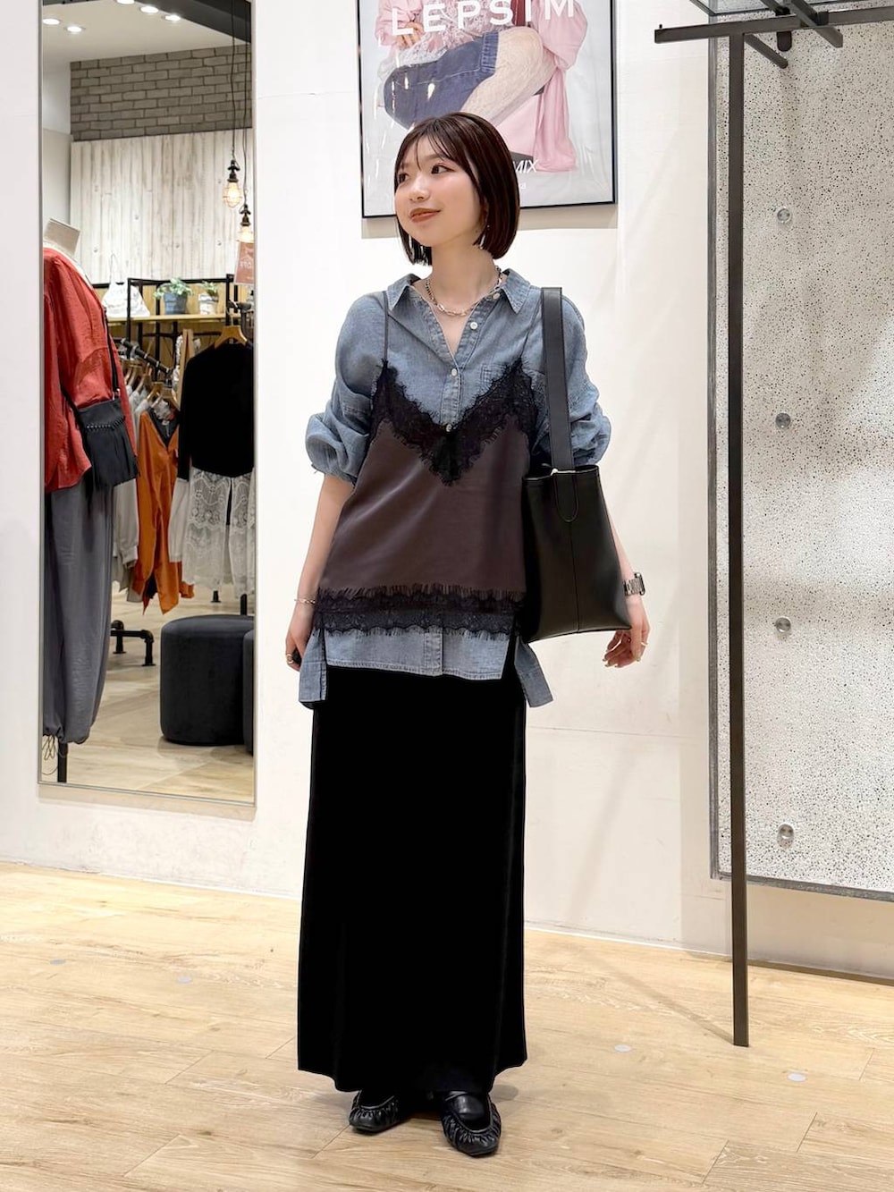 ブラック系のスカート、ブルー系のシャツ/ブラウス、ブラック系のトートバッグを着用したレディースの春コーディネートの5枚目の写真