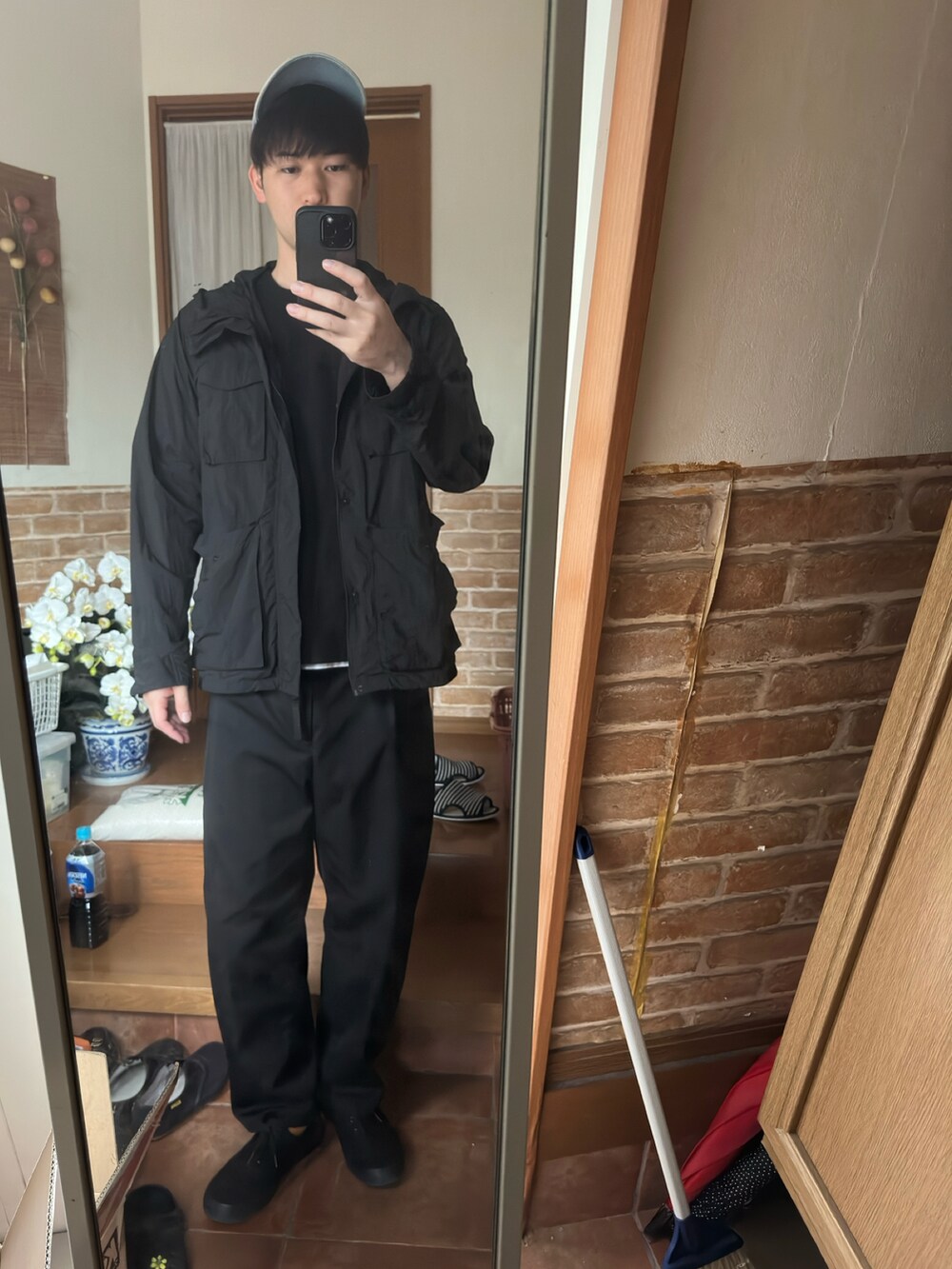 ブラック系のアンサンブル、ブラック系のスニーカー、ブラック系のスラックスを着用したメンズの春コーディネートの2枚目の写真