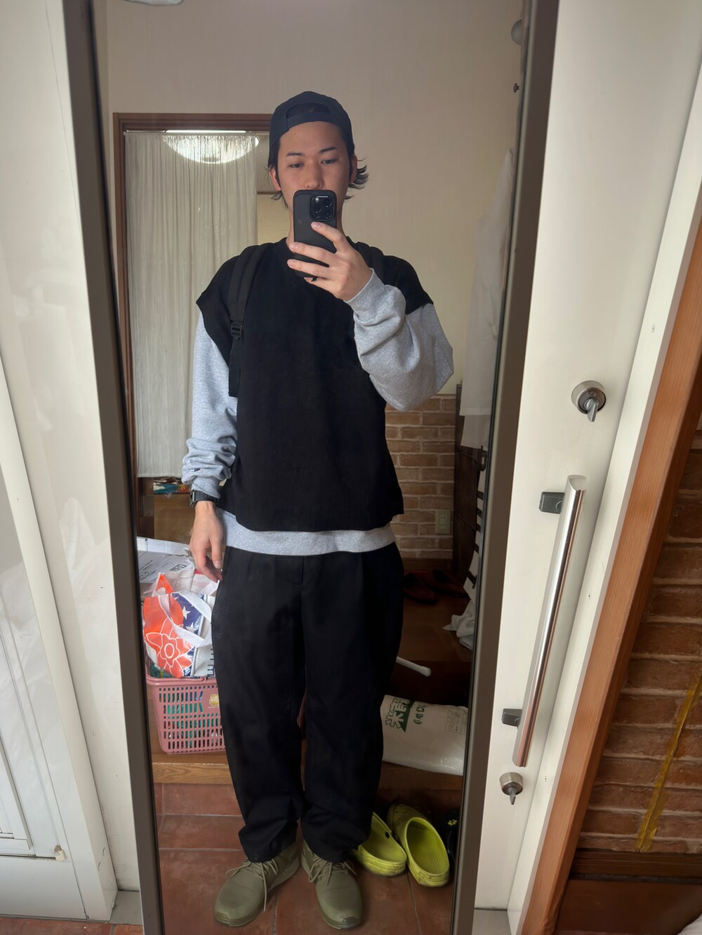 ブラック系のアンサンブル、ブラック系のパンツ、グリーン系のスニーカーを着用したメンズの春コーディネートの2枚目の写真