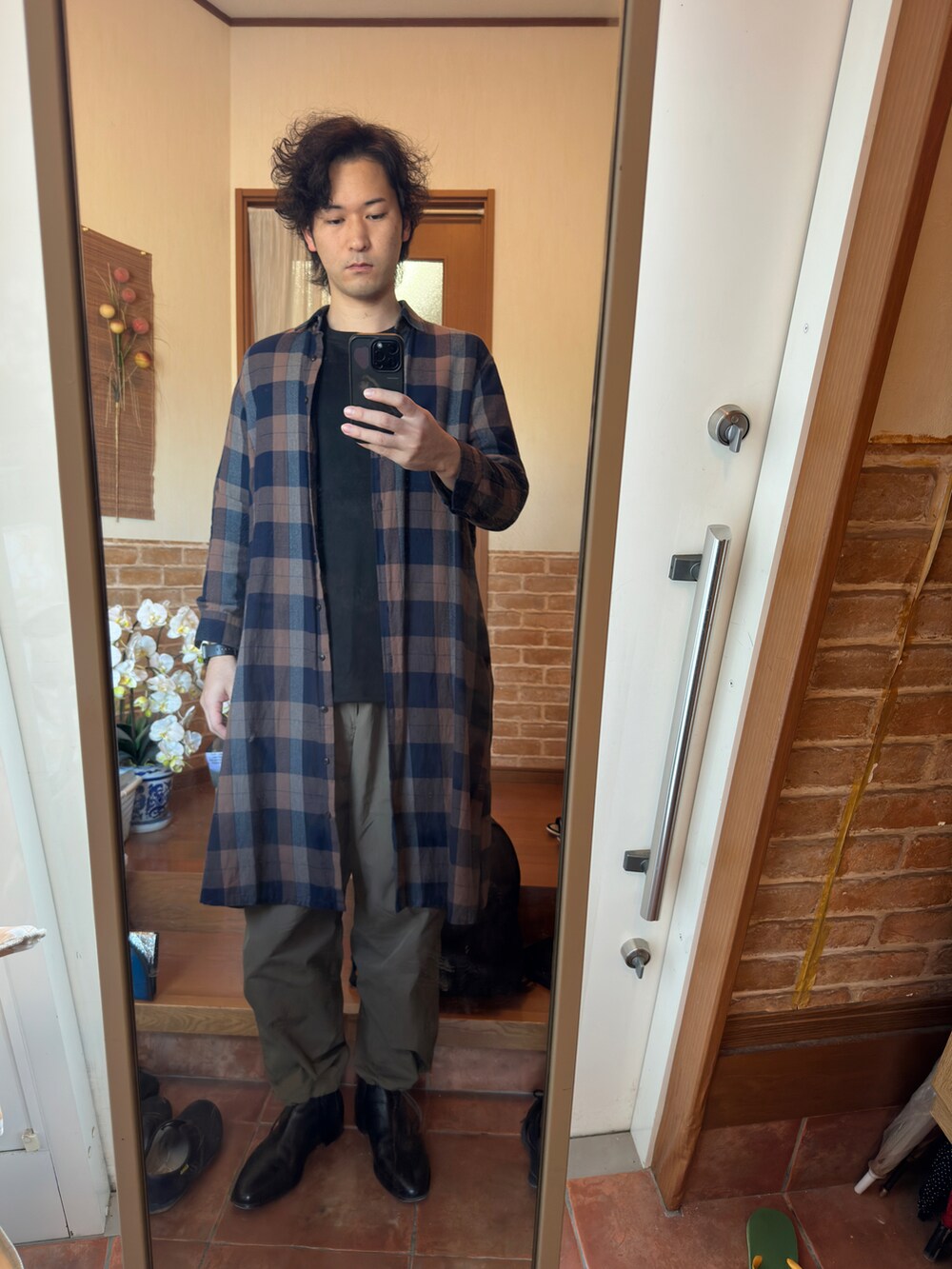 ブラック系のTシャツ/カットソー、グリーン系のカーゴパンツ、ブラック系のブーツを着用したメンズの秋コーディネートの2枚目の写真