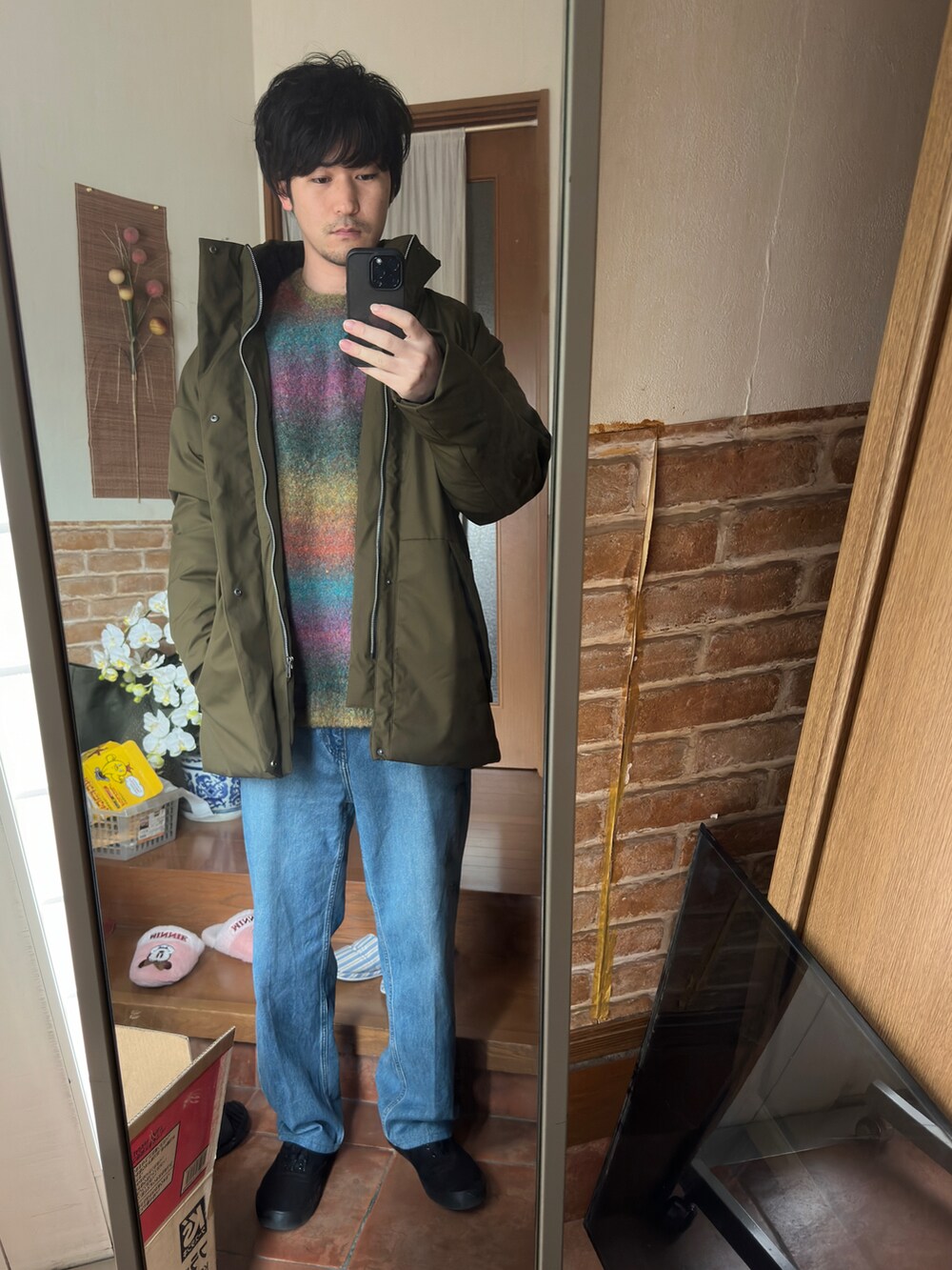 グリーン系のニット/セーター、ブルー系のデニムパンツを着用したメンズの冬コーディネートの2枚目の写真