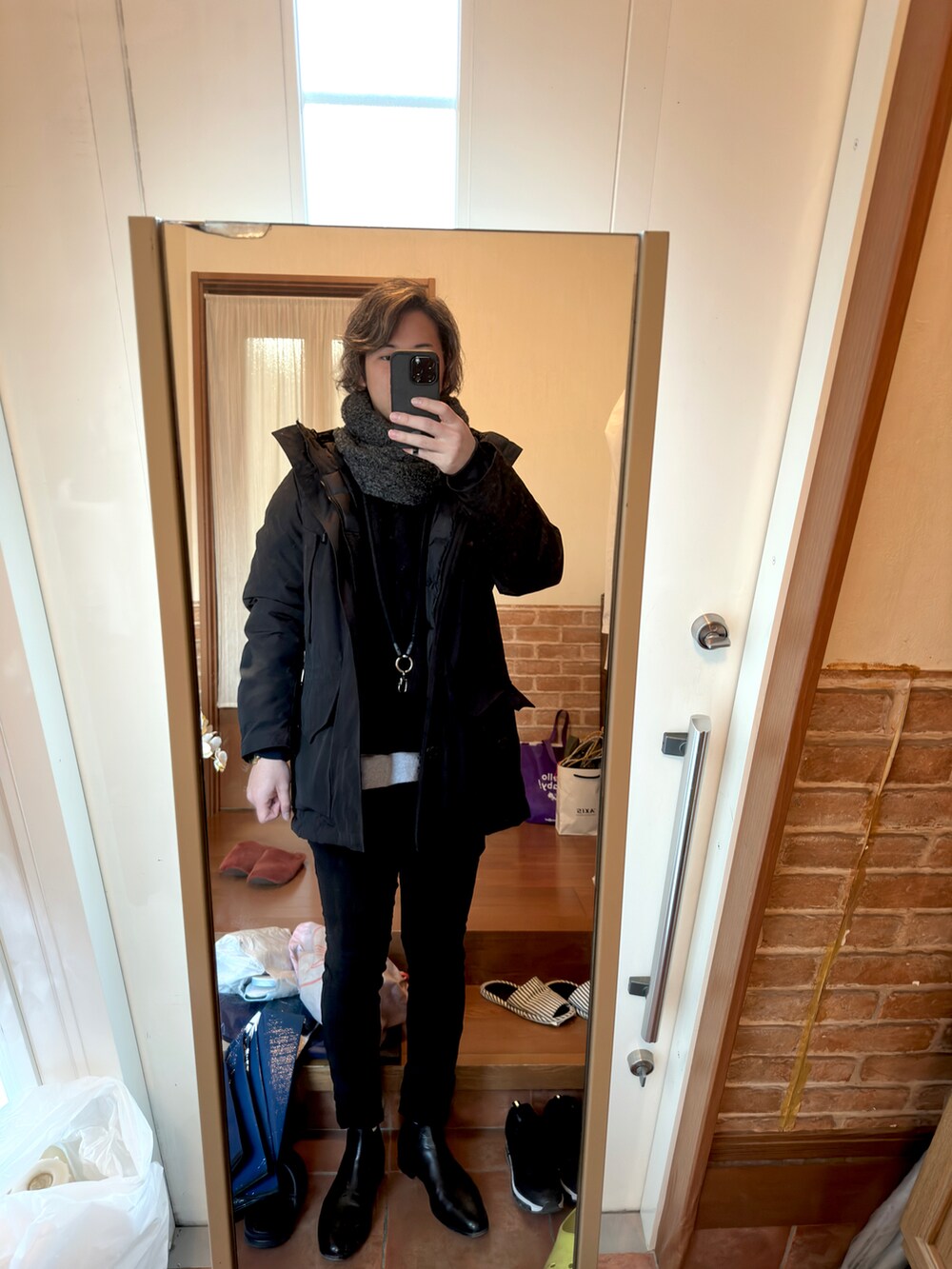 ブラック系のブーツ、ブラック系のアンサンブル、グレー系のスウェットを着用したメンズの冬コーディネートの2枚目の写真