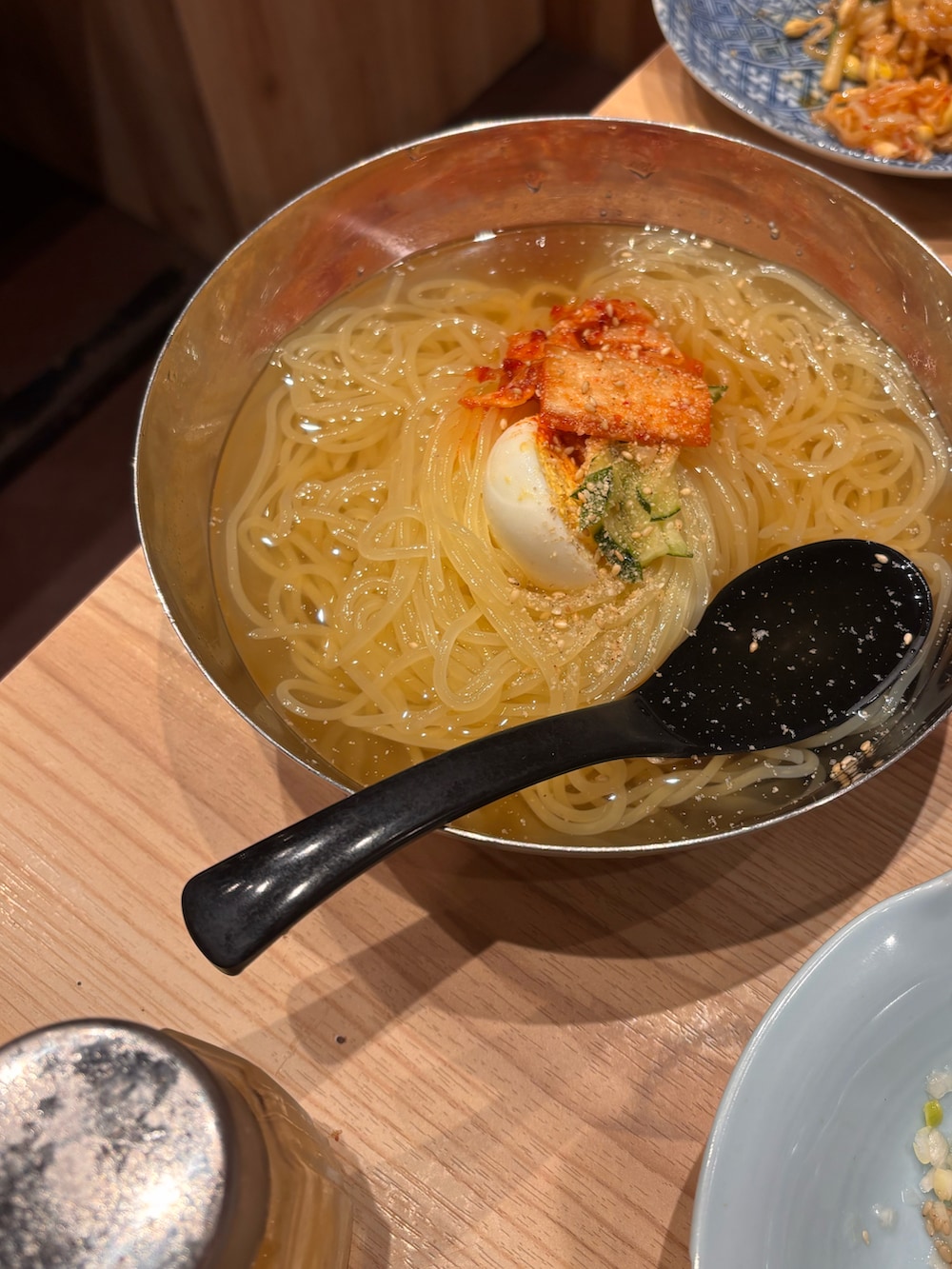 グリーン系のミリタリージャケット、ブラック系のスニーカー、グレー系のTシャツ/カットソーを着用したレディースの秋コーディネートの2枚目の写真