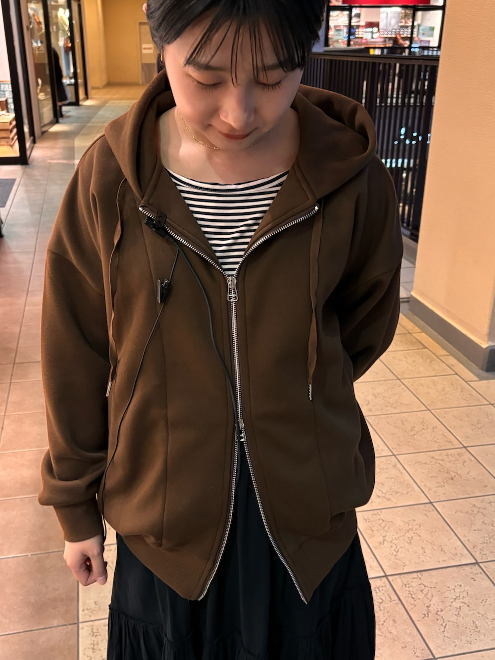 ブラック系のスカート、ブラック系のサンダルを着用したレディースの春コーディネートの2枚目の写真