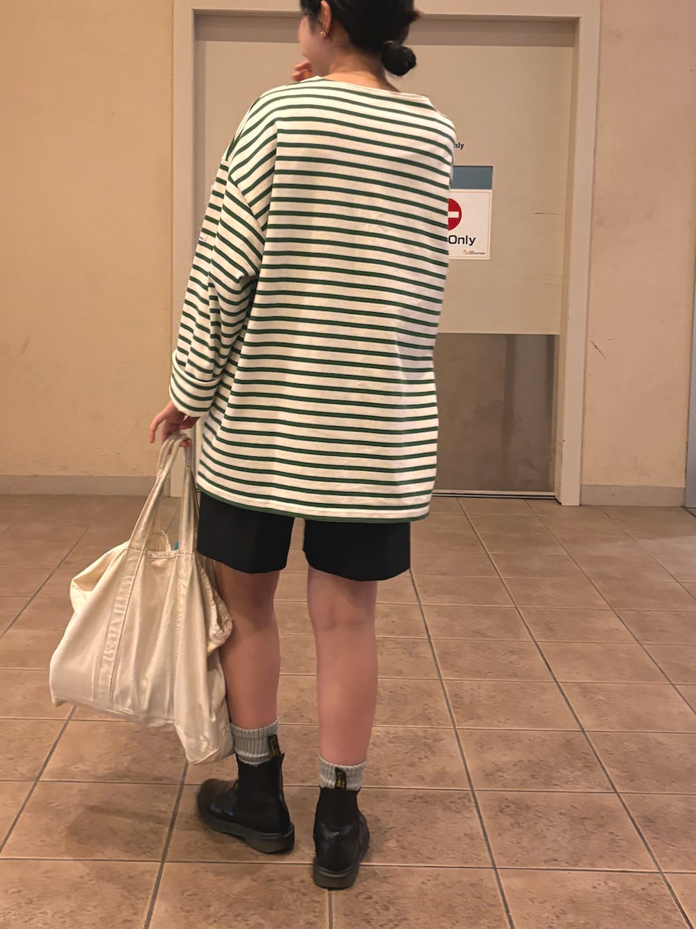 ホワイト系のトートバッグ、グリーン系のTシャツ/カットソー、ブラック系のその他パンツを着用したレディースの秋コーディネートの3枚目の写真