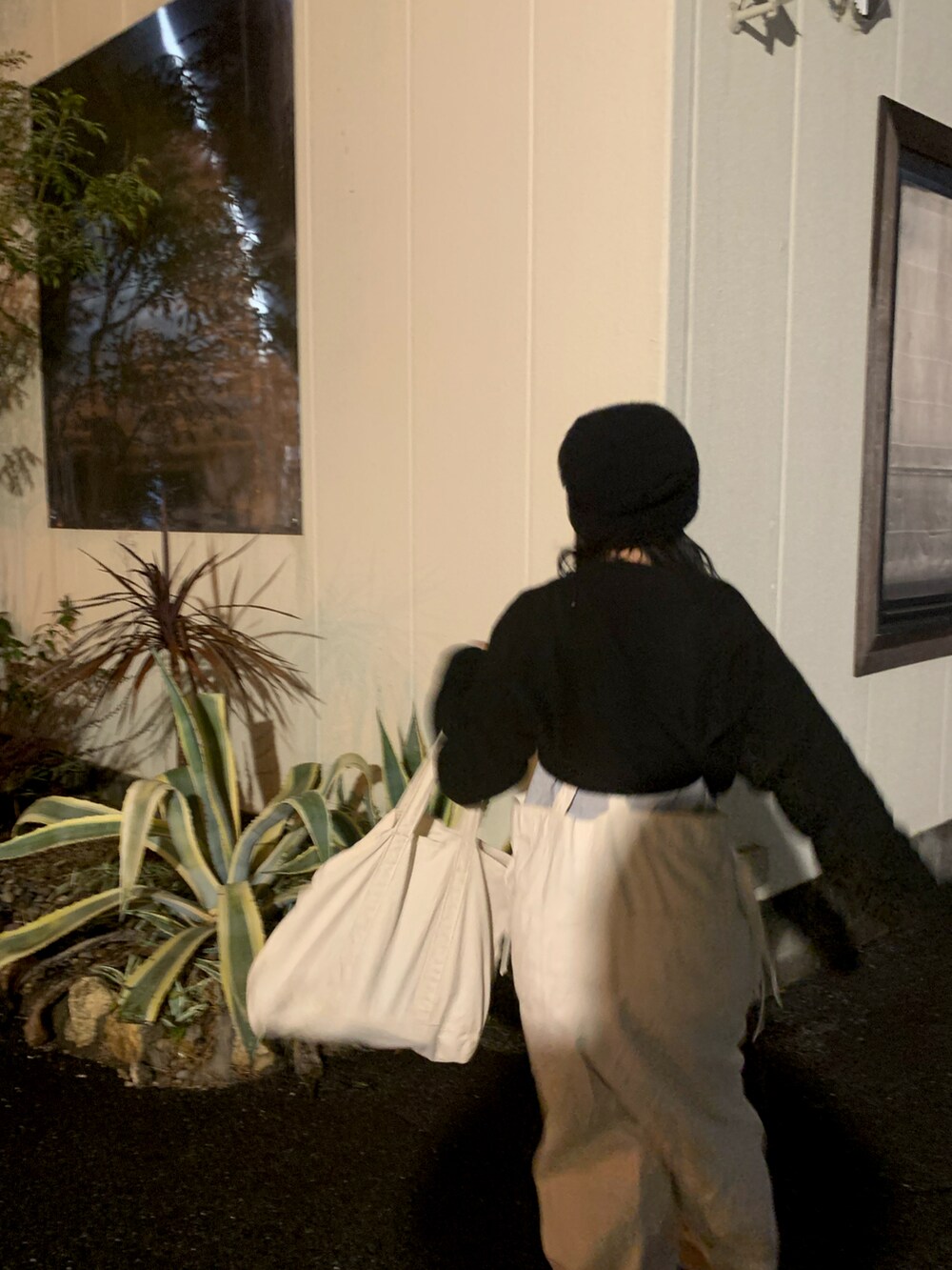 ホワイト系のトートバッグ、ブルー系のスニーカー、ベージュ系のサロペット/オーバーオールを着用したレディースの冬コーディネートの2枚目の写真