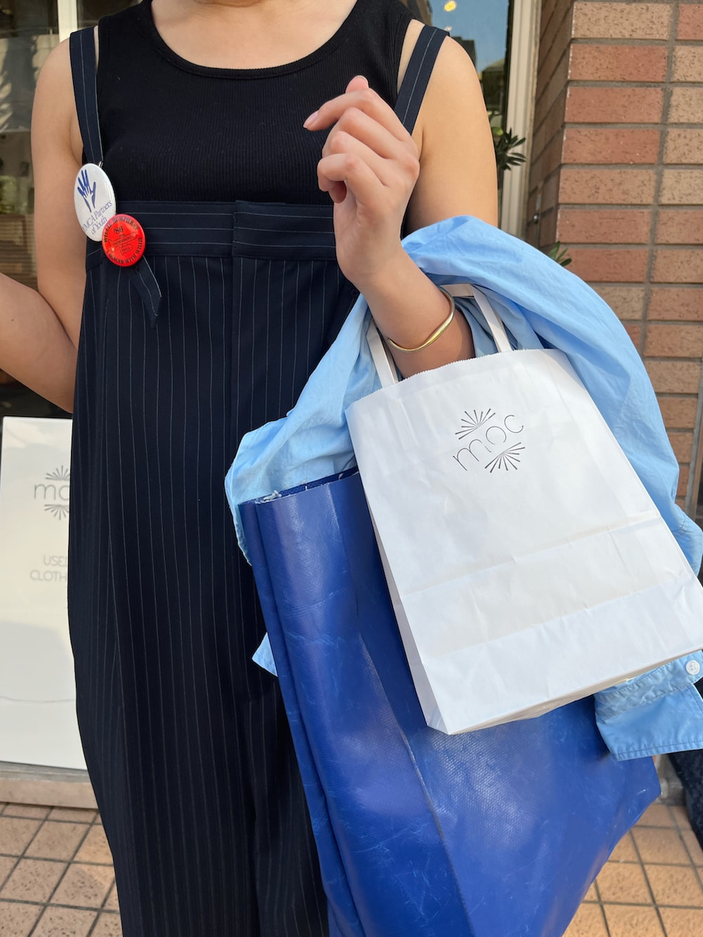 ブルー系のつなぎ/オールインワン、ホワイト系のスニーカー、ブルー系のバッグを着用したレディースの夏コーディネートの3枚目の写真