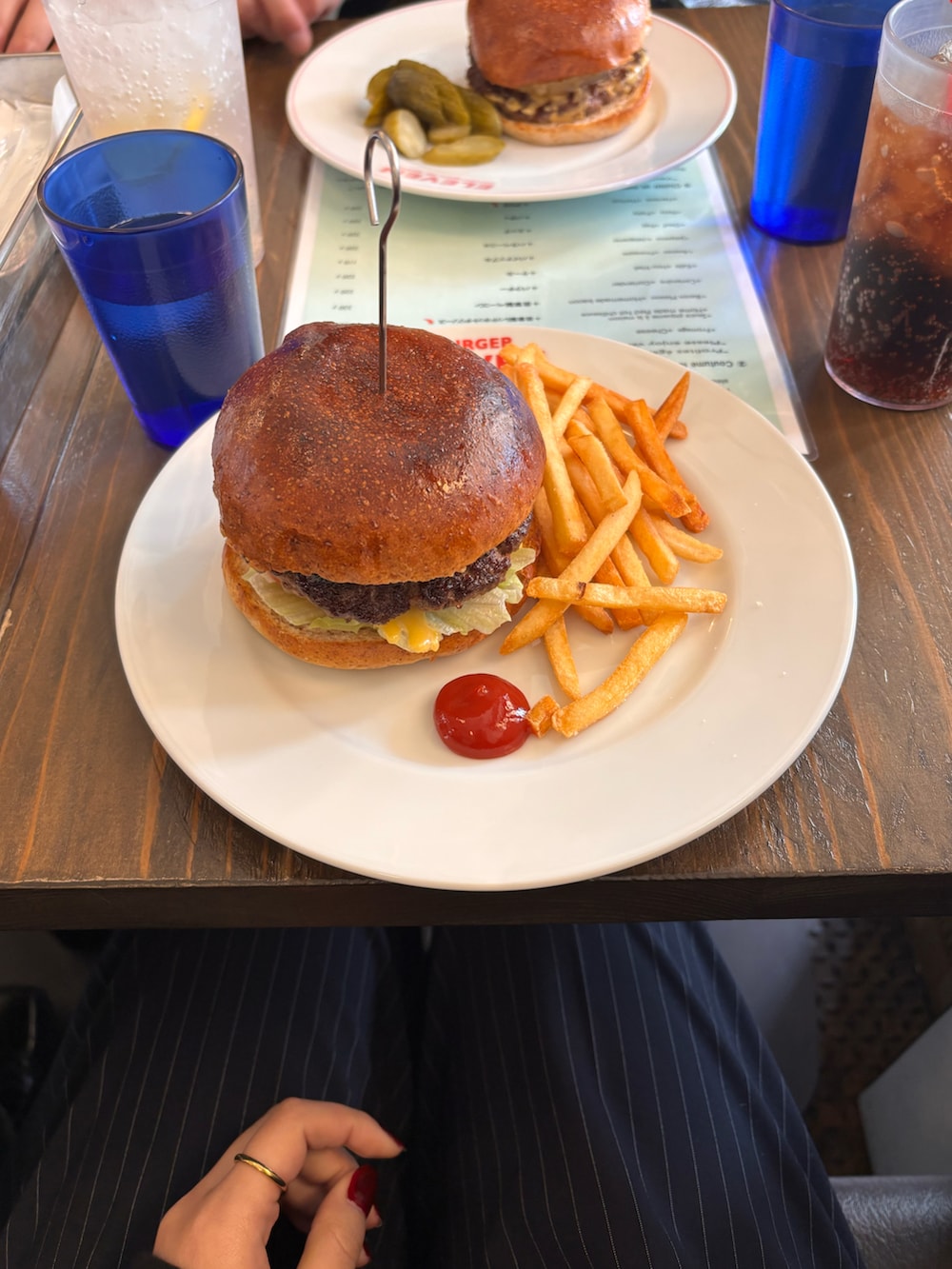 ブルー系のつなぎ/オールインワン、ホワイト系のスニーカー、ブラック系のトップスを着用したレディースの春コーディネートの2枚目の写真