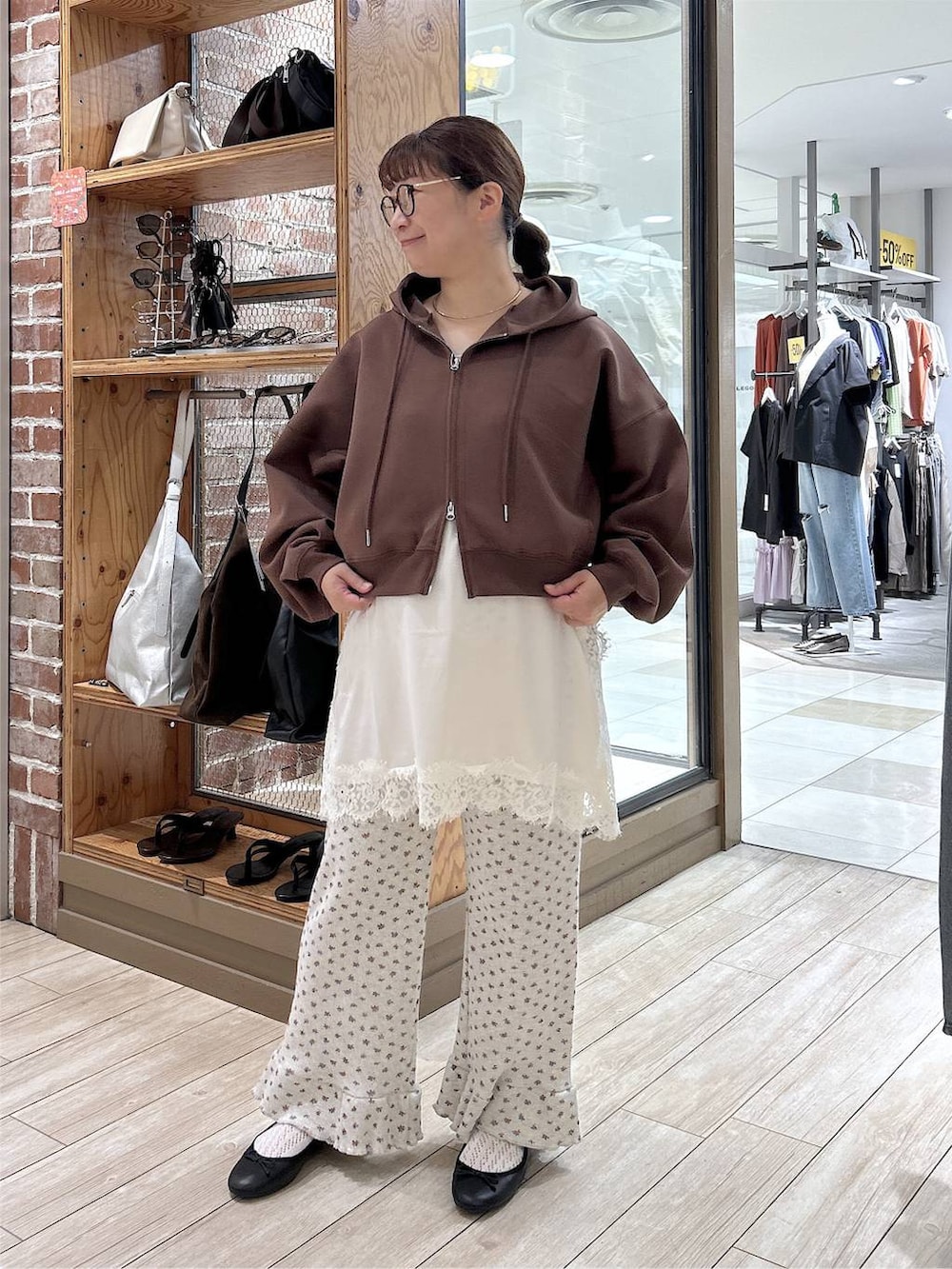 グレー系のその他パンツ、ブラック系のバレエシューズ、ホワイト系のキャミソールを着用したレディースの秋コーディネートの3枚目の写真