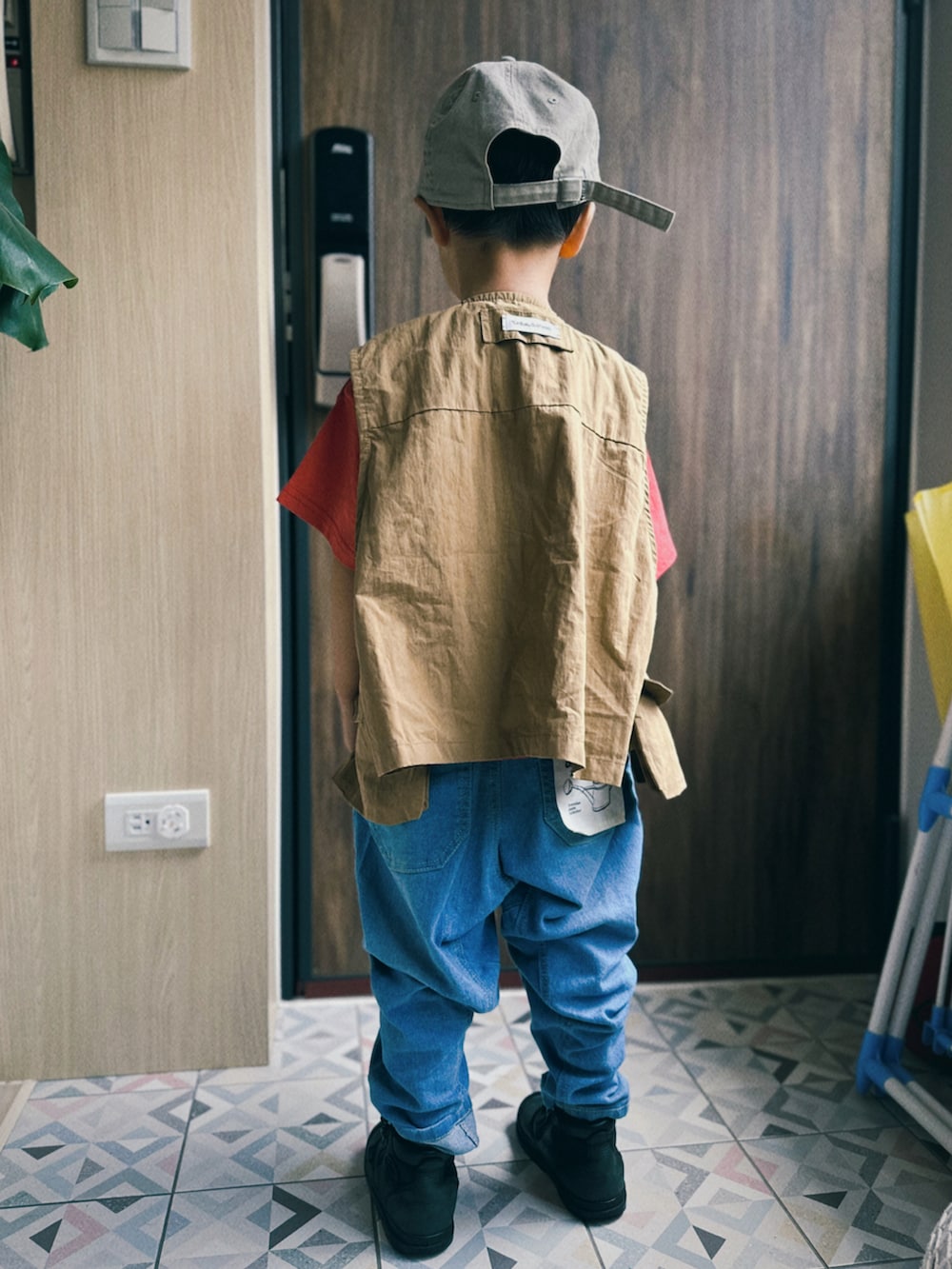 ブルー系のデニムパンツ、ブラック系のブーツ、レッド系のTシャツ/カットソーを着用したキッズの秋コーディネートの3枚目の写真
